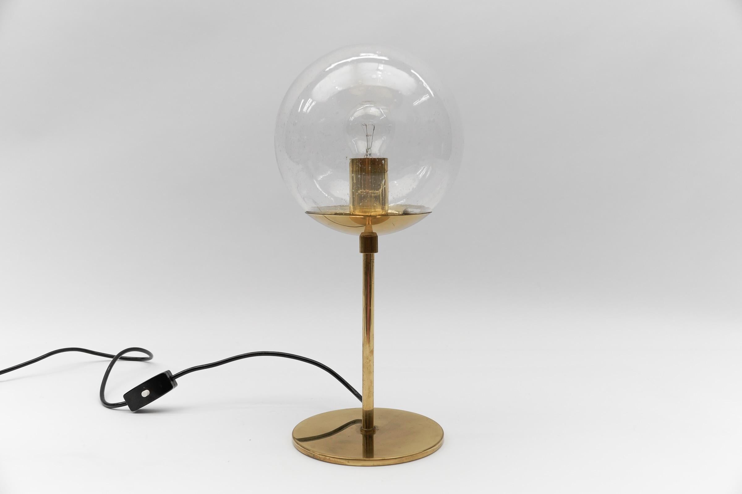 Mid-Century Modern Table Lamp made in Brass and Glass, 1960s

Dimension
Height: 16.92 in (43 cm)
Diameter: 7.87 in (20 cm)

The lamp needs 1 x E27 / E26 Edison screw fit bulb, is wired, and in working condition. It runs both on 110 / 230 volt.

Very