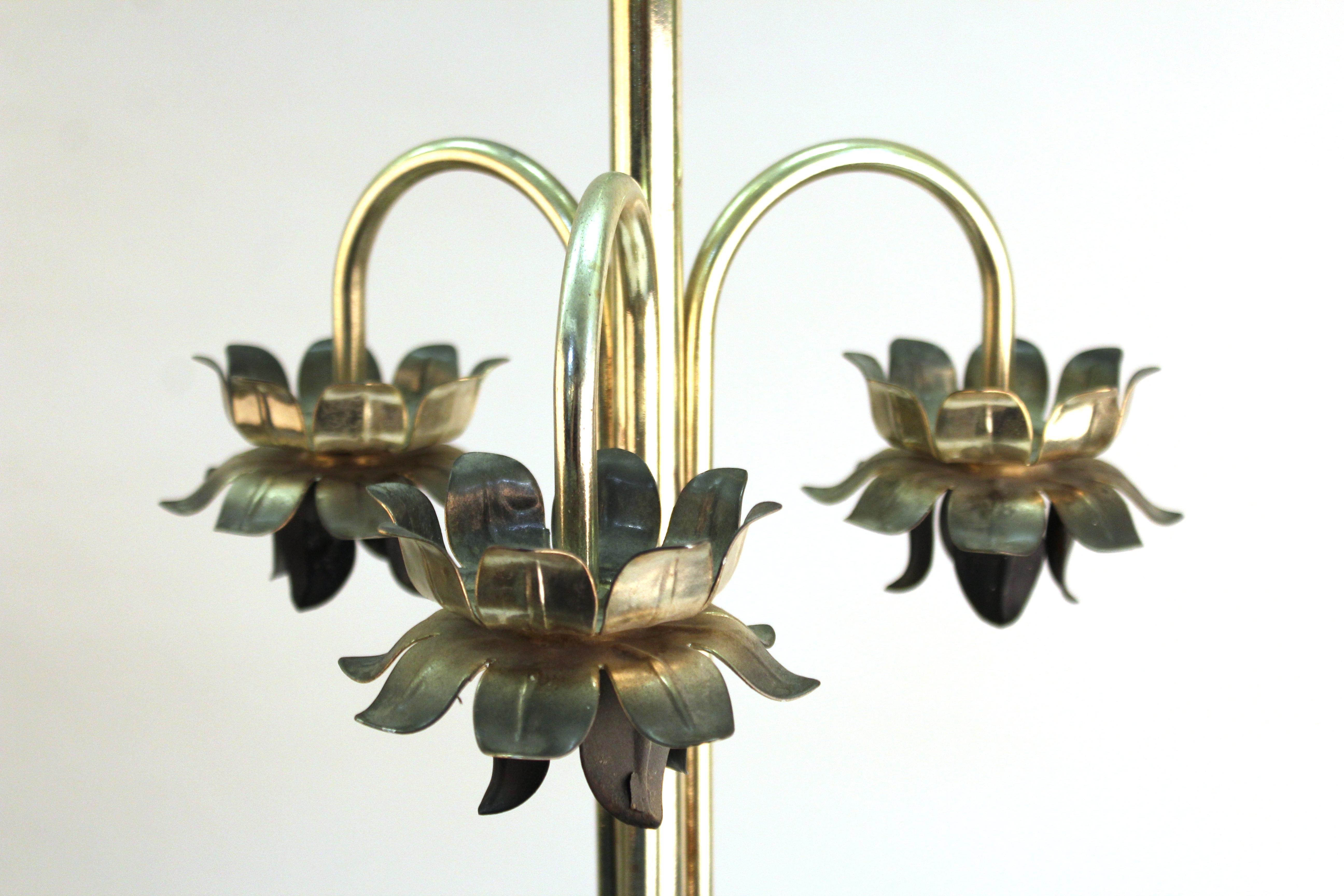 Mid-Century Modern metal table lamp with curved leaves at the circular base and three flower buds with petals. Two light bulb sockets on the top. The piece is in great vintage condition with age-appropriate wear.