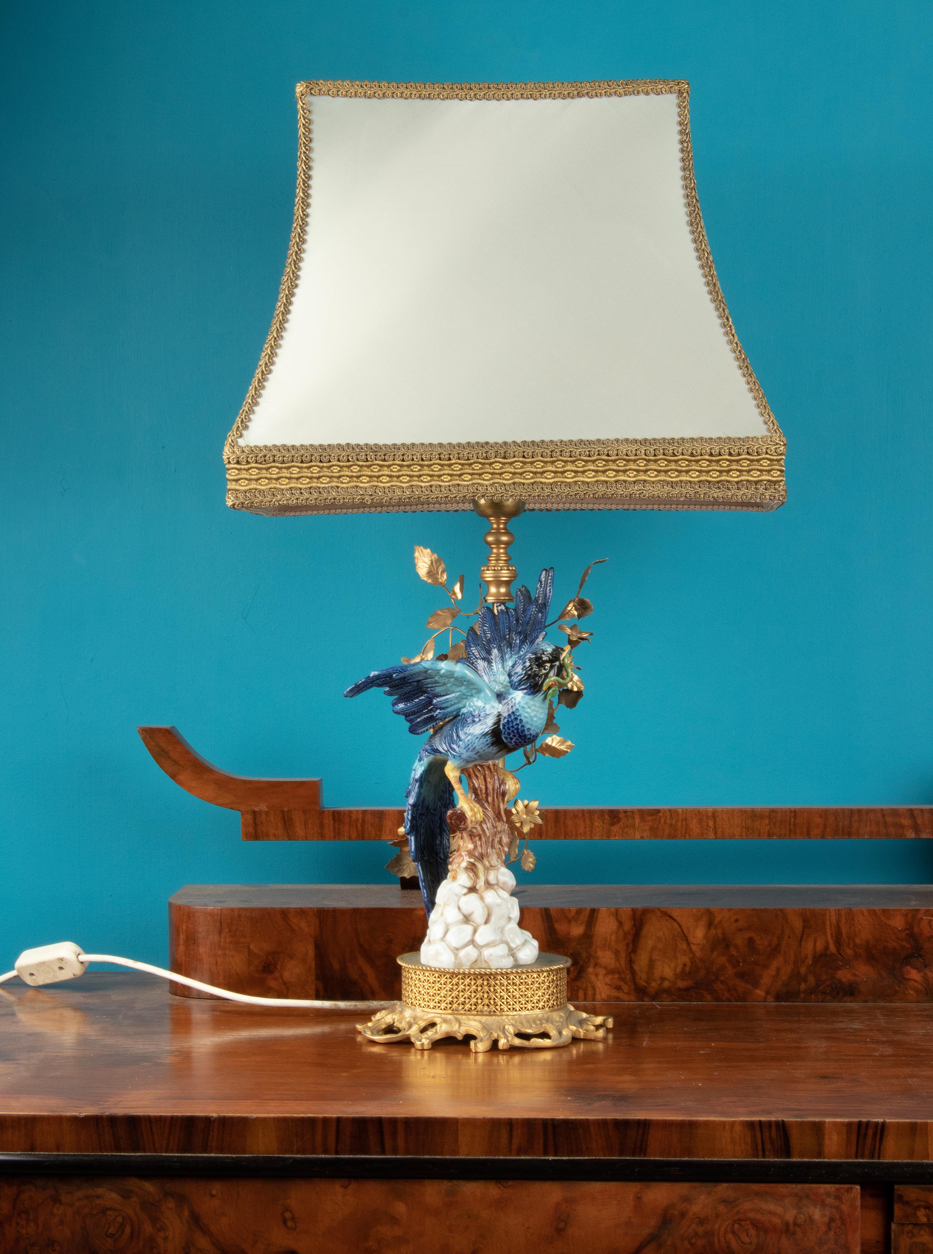 Nice Vintage table lamp, with a figurine of a blue parrot, made of porcelain. The lamp foot is made of bronze and leafs are made of copper. The porcelain is marked Sèvres. The lamp shade is made of silk fabric, and has some small stains in the