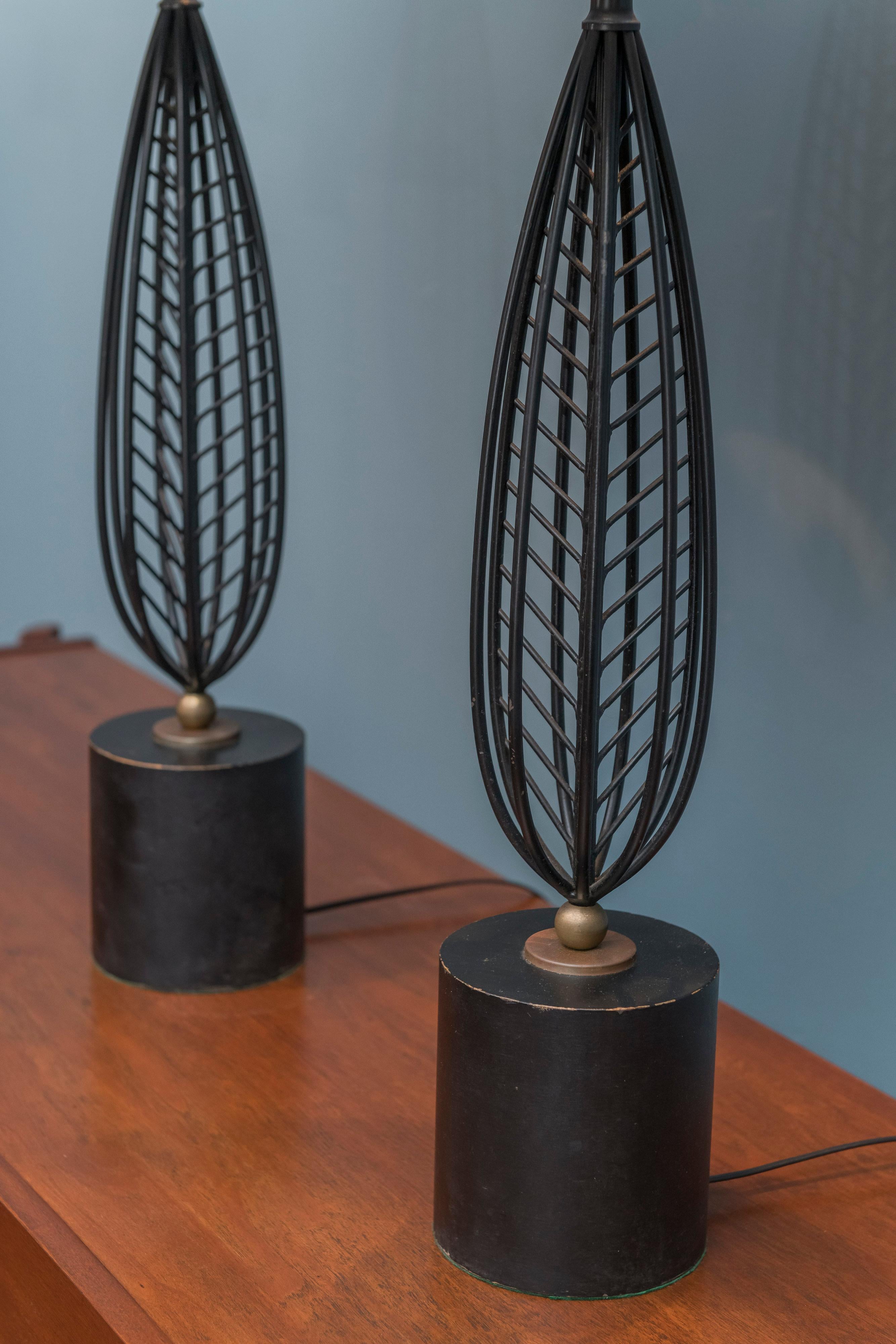 Mid-Century Modern table lamps made from painted black steel with gold accents on wood bases. Newly re-wired and restored. Height to the socket 27
