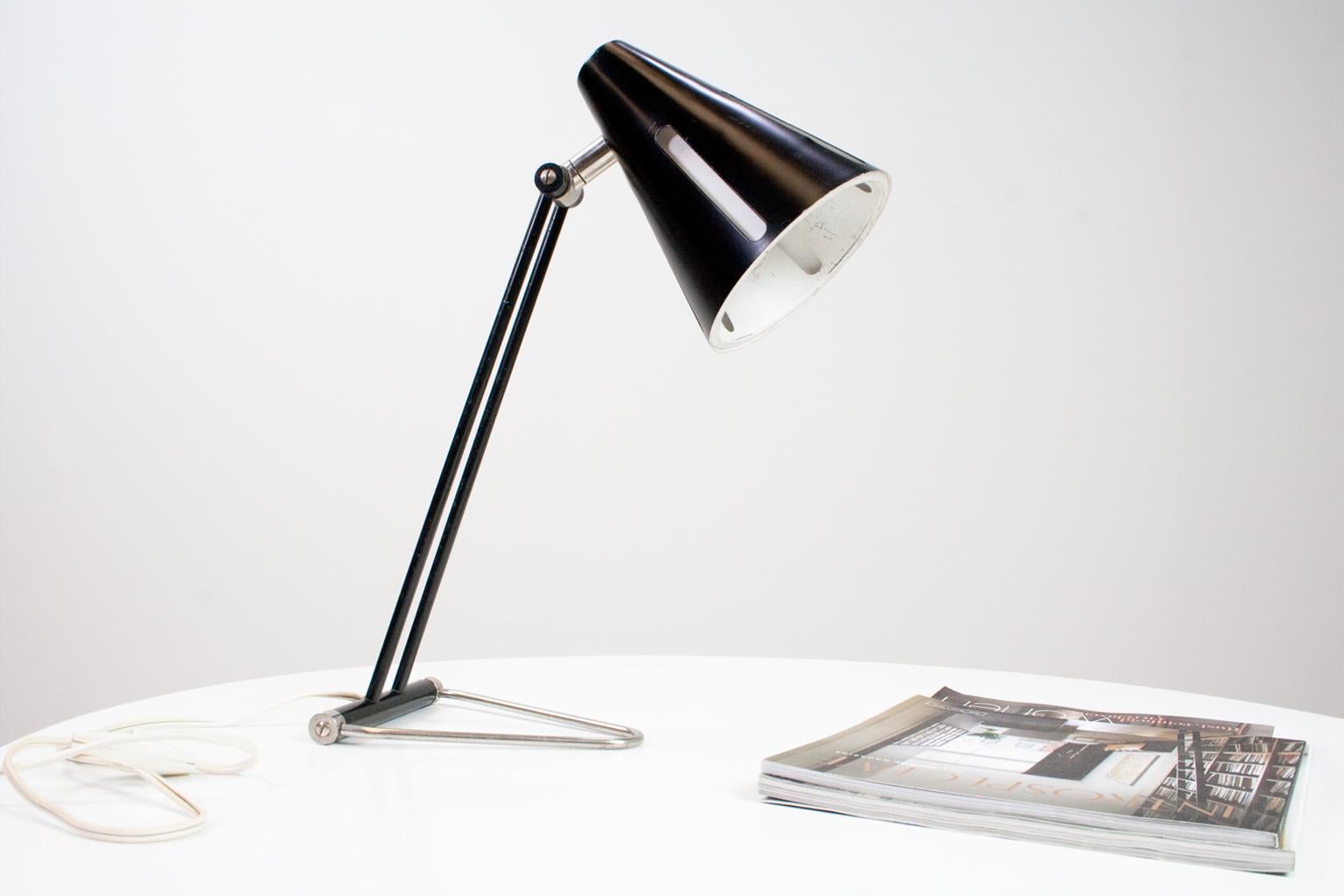 Elegant and well preserved desk or table lamp by H.Busquet for Hala, part of the Sun / Solar series 1955 (Zonneserie). The desk light with a black and white cap and special reflector construction can be used for either direct as diffuse light. Both