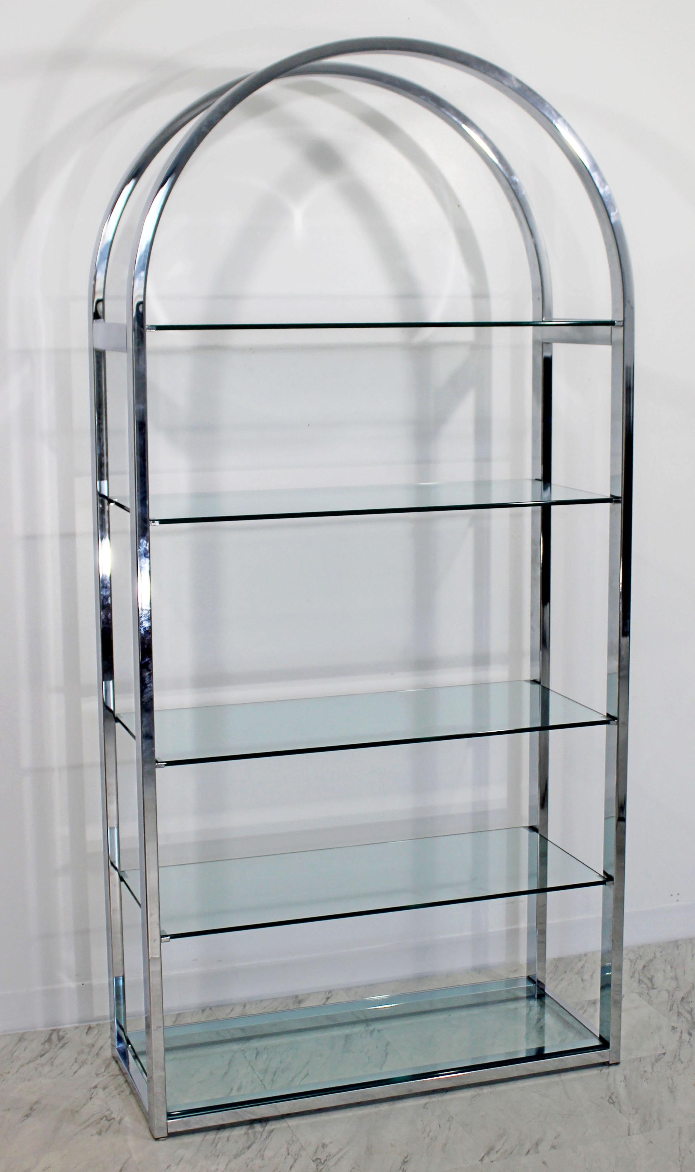 For your consideration is an incredible and unique, curved chrome étagère shelving unit, with five glass shelves, by Milo Baughman, circa the 1970s. In excellent condition. The dimensions are 38.25