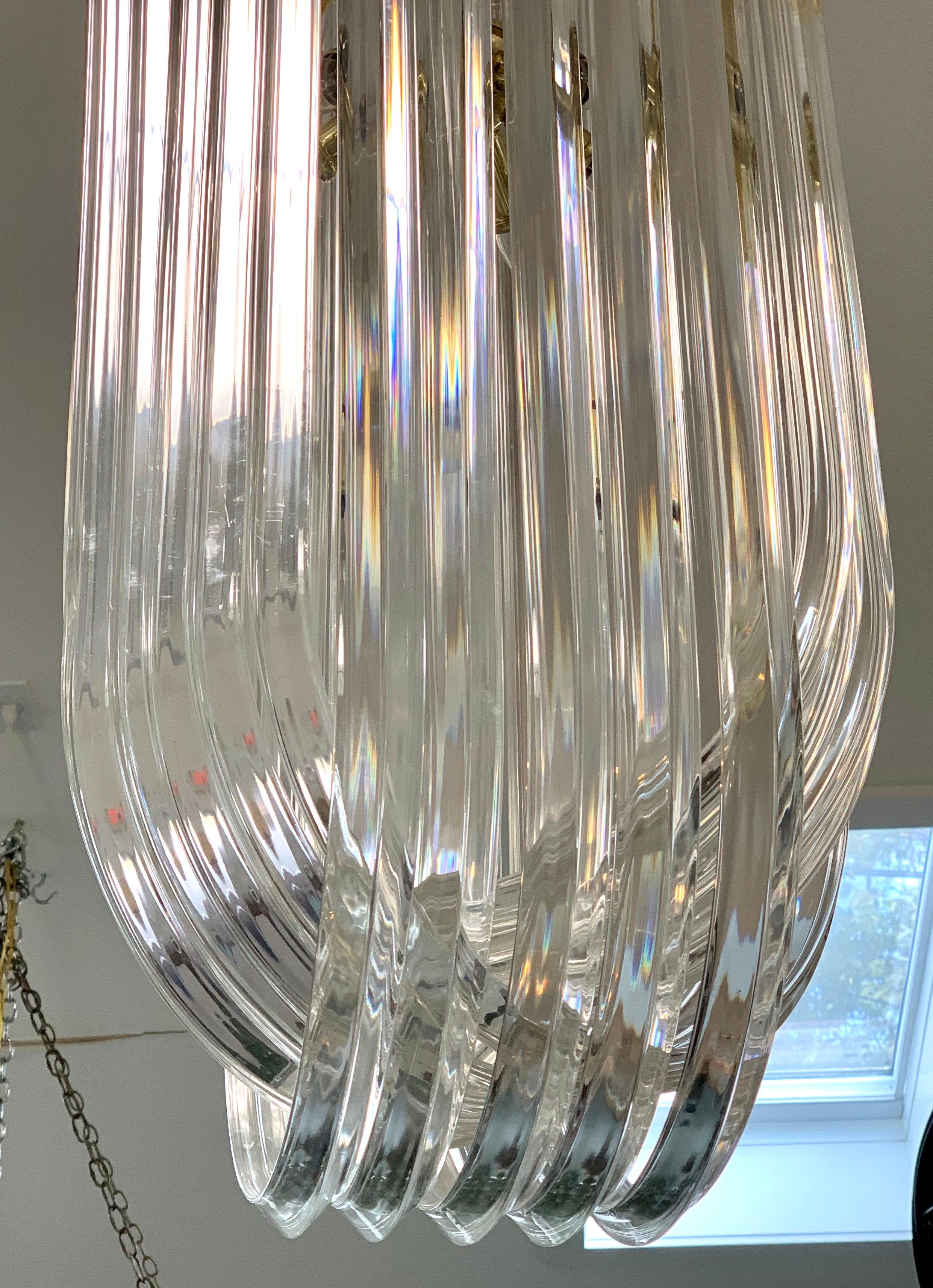 Spectacular, tall Mid-Century Modern chandelier where the Lucite is curved in infinity loops. Nothing short of stunning. Wired for USA and in working order. Multiple lights, see pics. Now, more than ever, home is where the heart is.