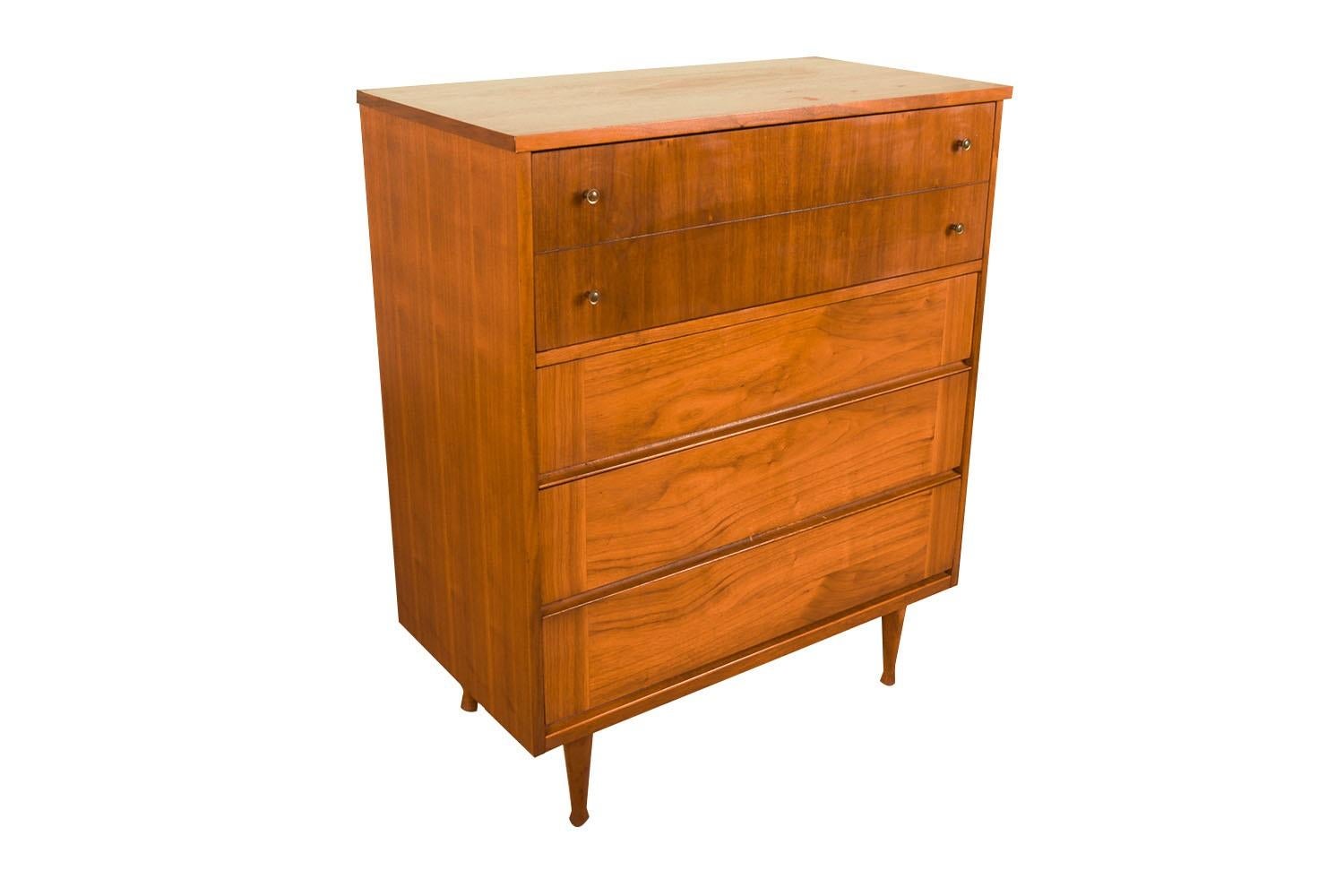 Attractive tall mid century modern sleek smooth face dresser. This is a very simple yet modern design. Each drawer has beautiful medium tone stunning walnut grains with minimal pulls. At the pull of the drawers you will expose plenty of storage. A