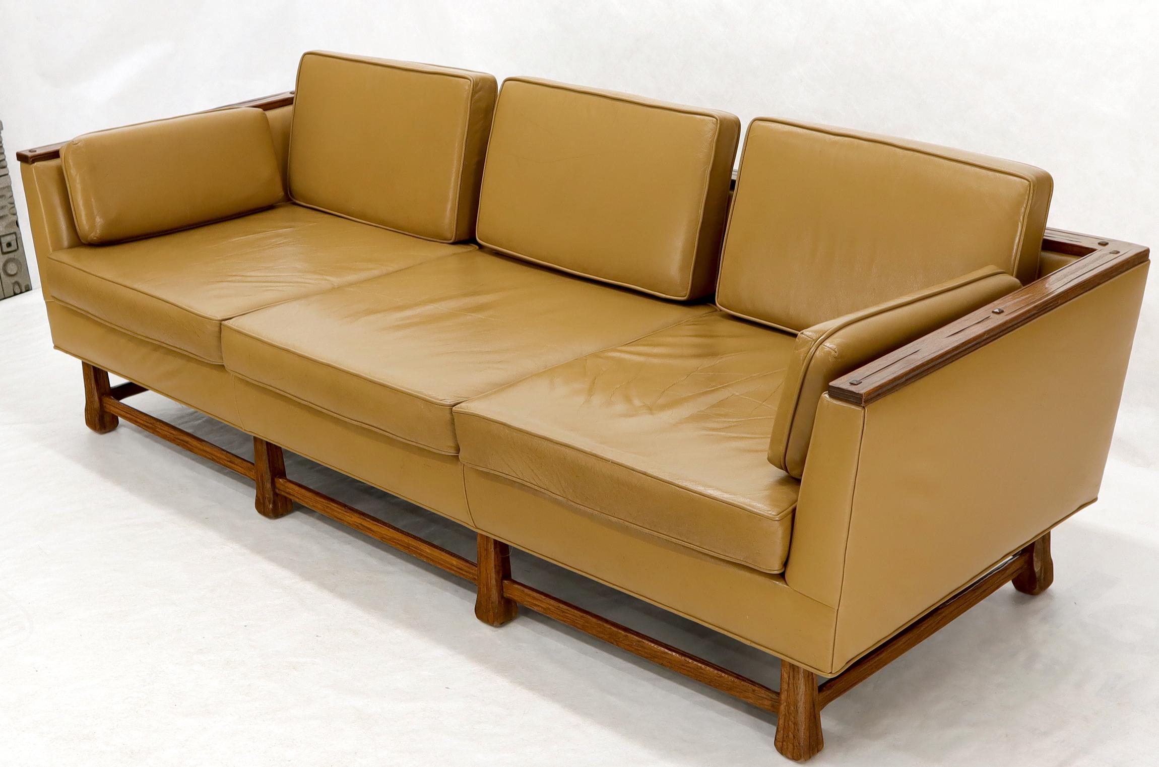 Oak frame tan supple leather upholstery Mid-Century Modern sofa. Artistic adze cut wood finishing technique presence detail.
