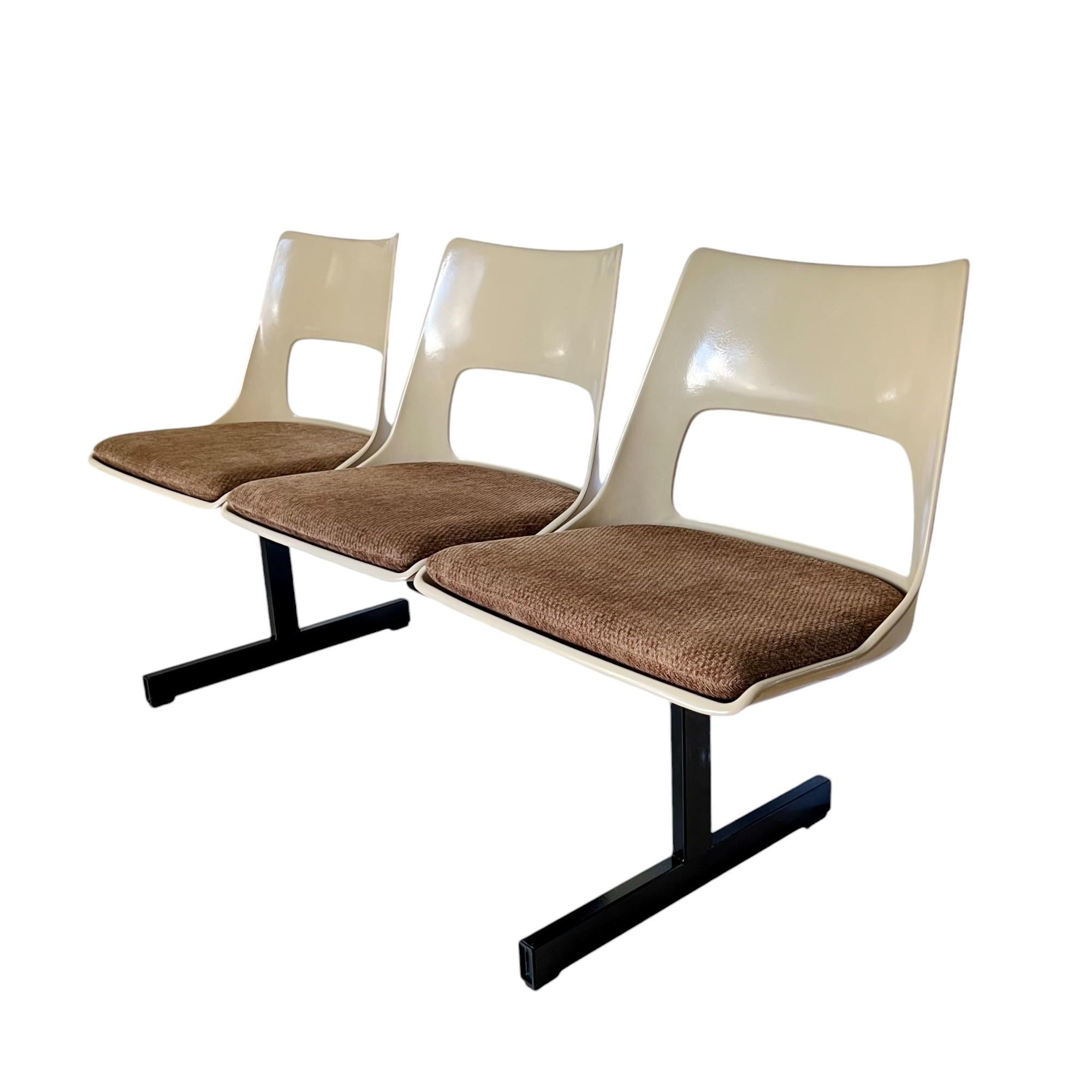 Vintage mid-century modern tandem beam seating by Krueger International circa 1969. This bench features three molded fiberglass light beige color shells connected on a black steel stretcher frame. The fiberglass seats are vented and slotted for