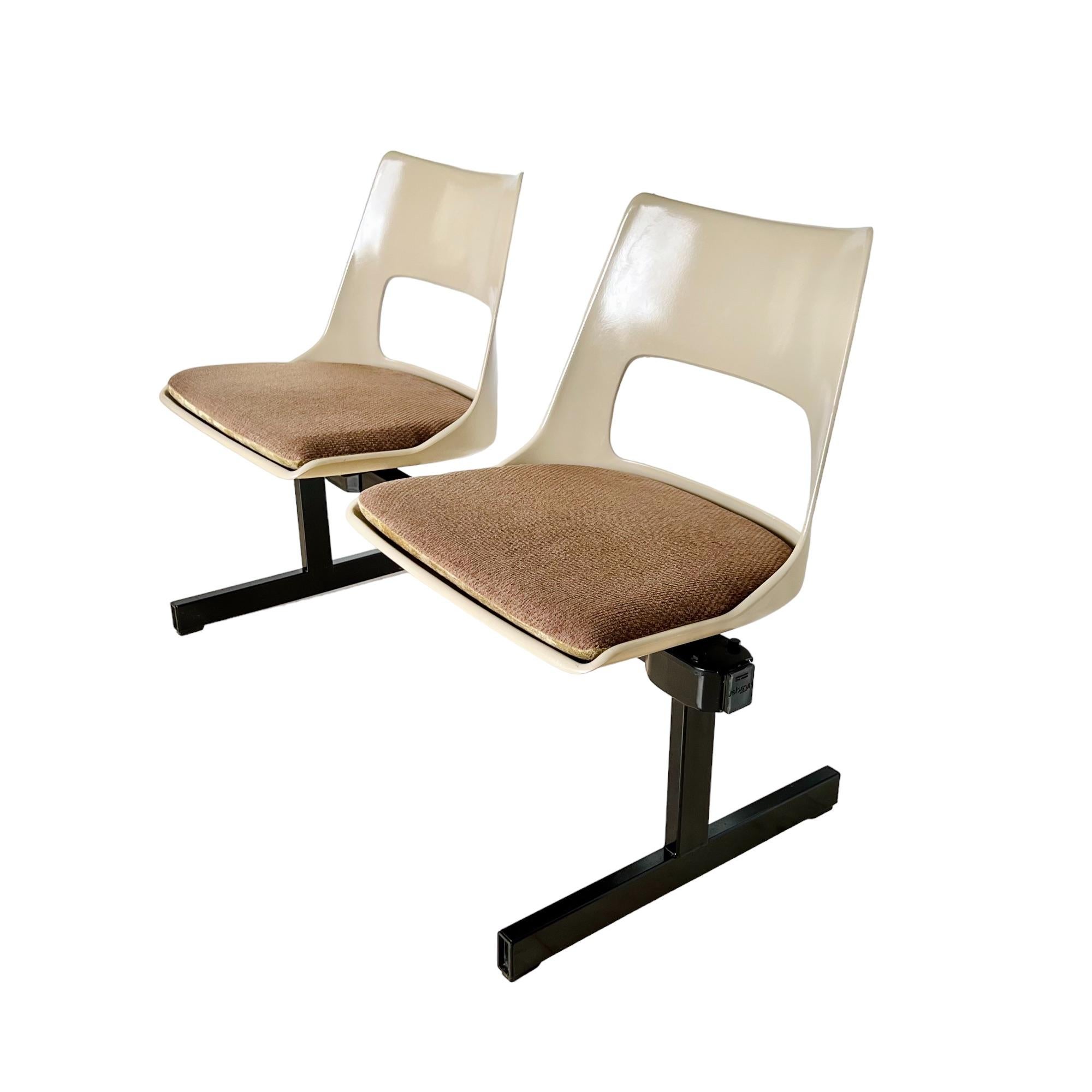 Vintage Mid-Century Modern tandem beam seating by Krueger International circa 1970. This bench features two molded fiberglass light beige color shells connected on a black metal stretcher frame. The fiberglass seats are vented and slotted for