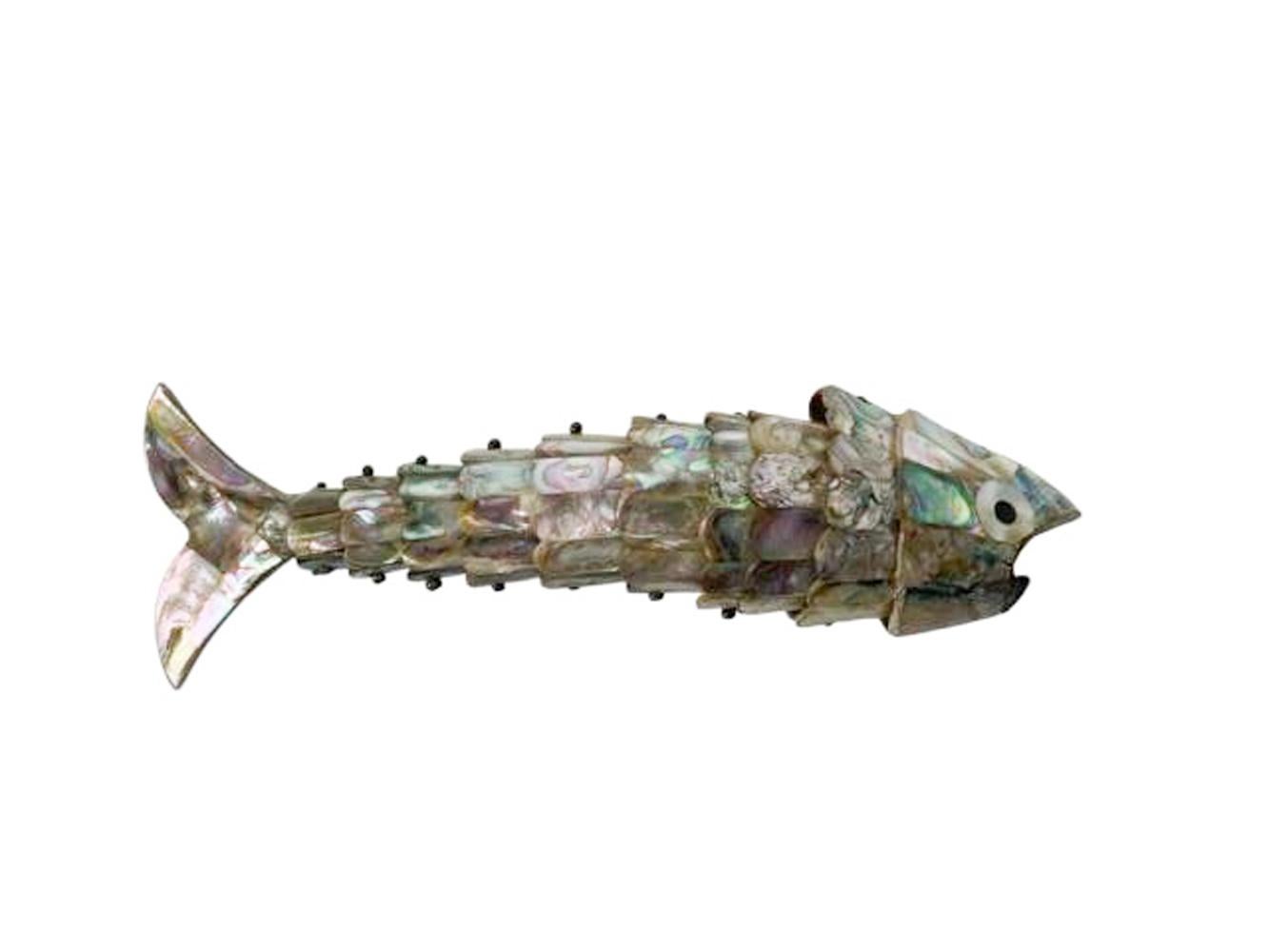 Articulated silver plate fish-form bottle opener with pieces of polished abalone shell applied as scales. Brass disk label applied to tail reads 