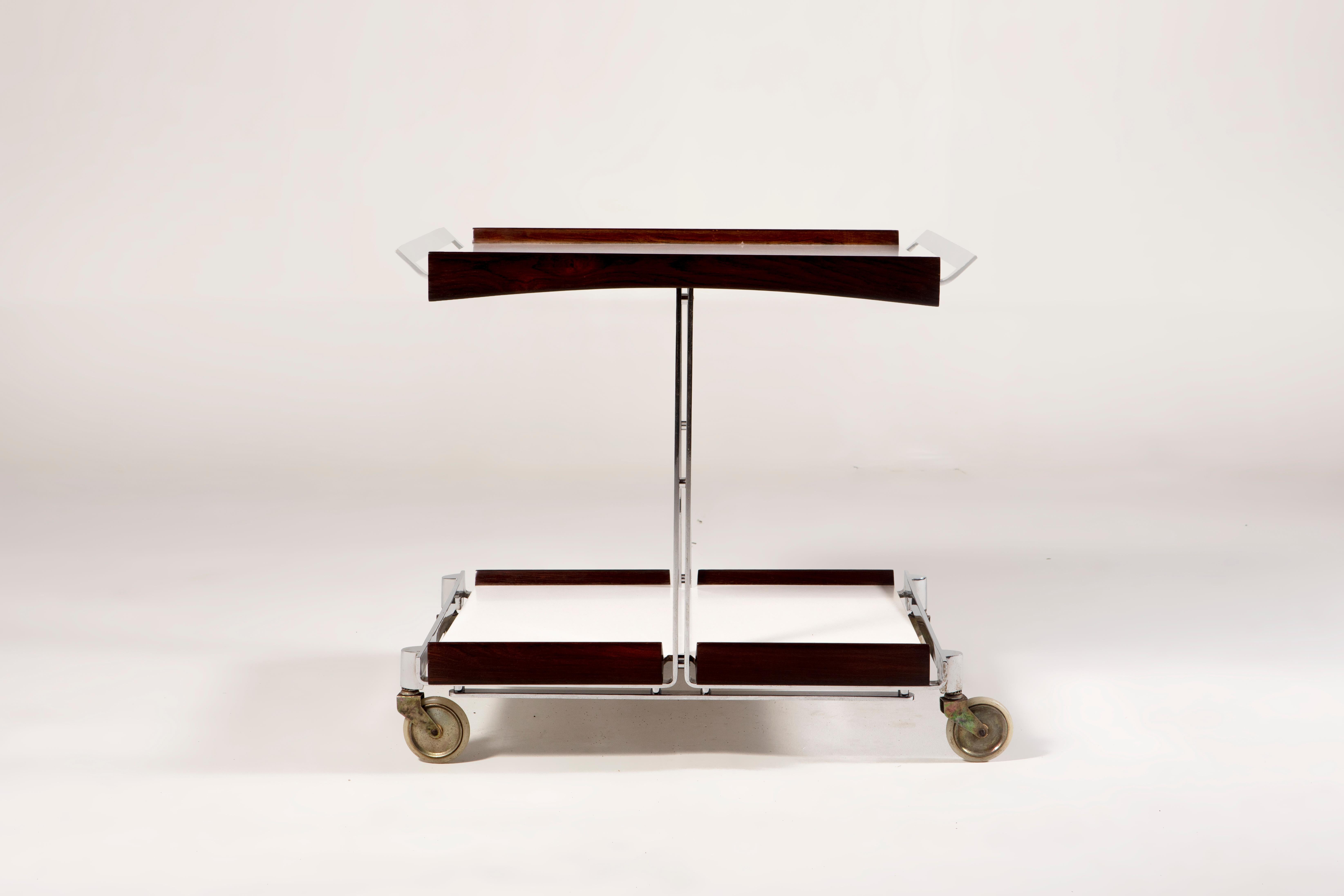Mid-Century Modern Tea Cart by Forma, 1960s

Mid-Century Modern Tea Cart manufactured by Forma Manufatura circa 1950 and designed by Carlo Hauner and Martin Eisler.
It has square Formica tops and wooden sides, with chromed metal handles and has