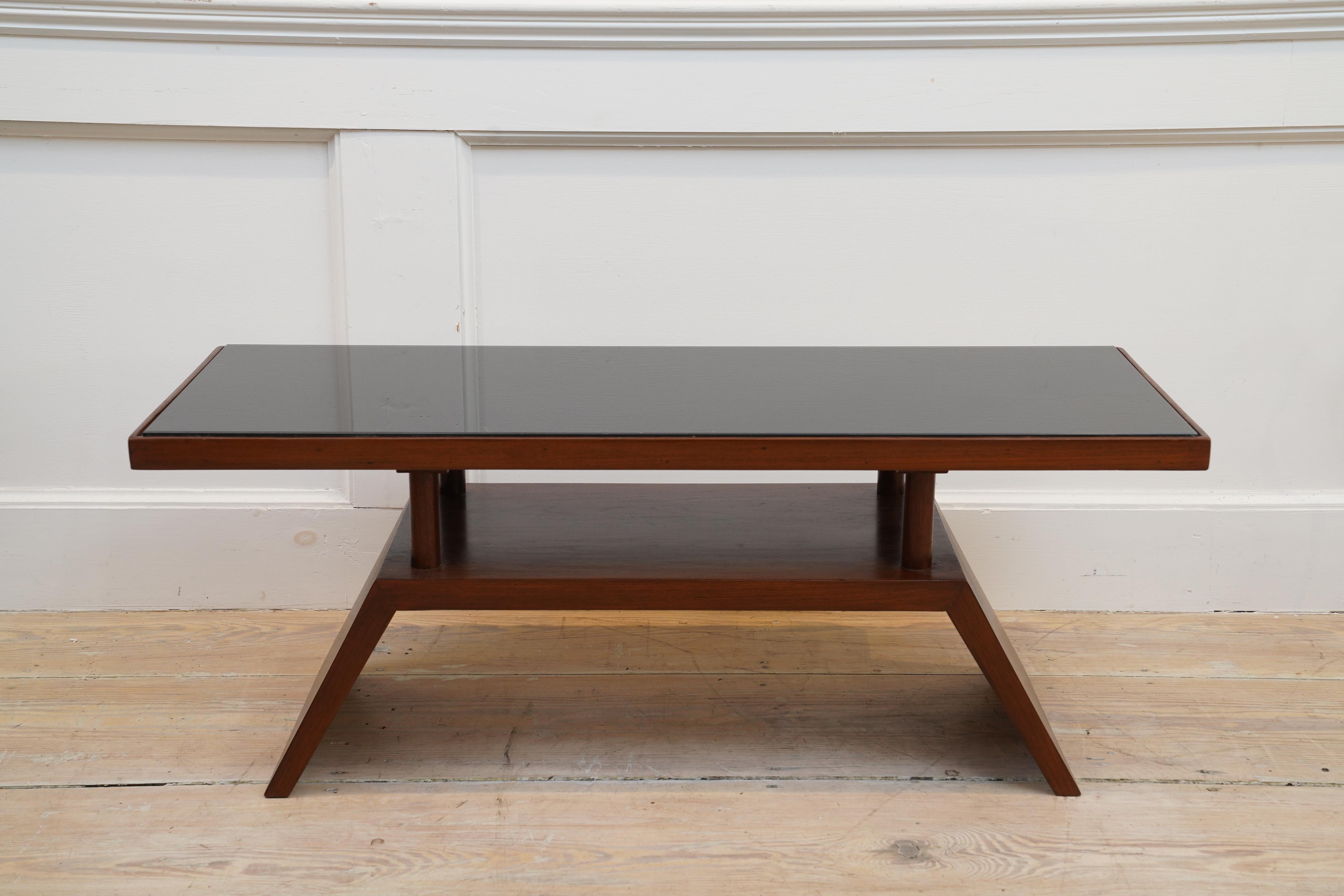 A stunning and architectural teak wood coffee table with recessed black glass top. Mid-Century Modern, 1970's.