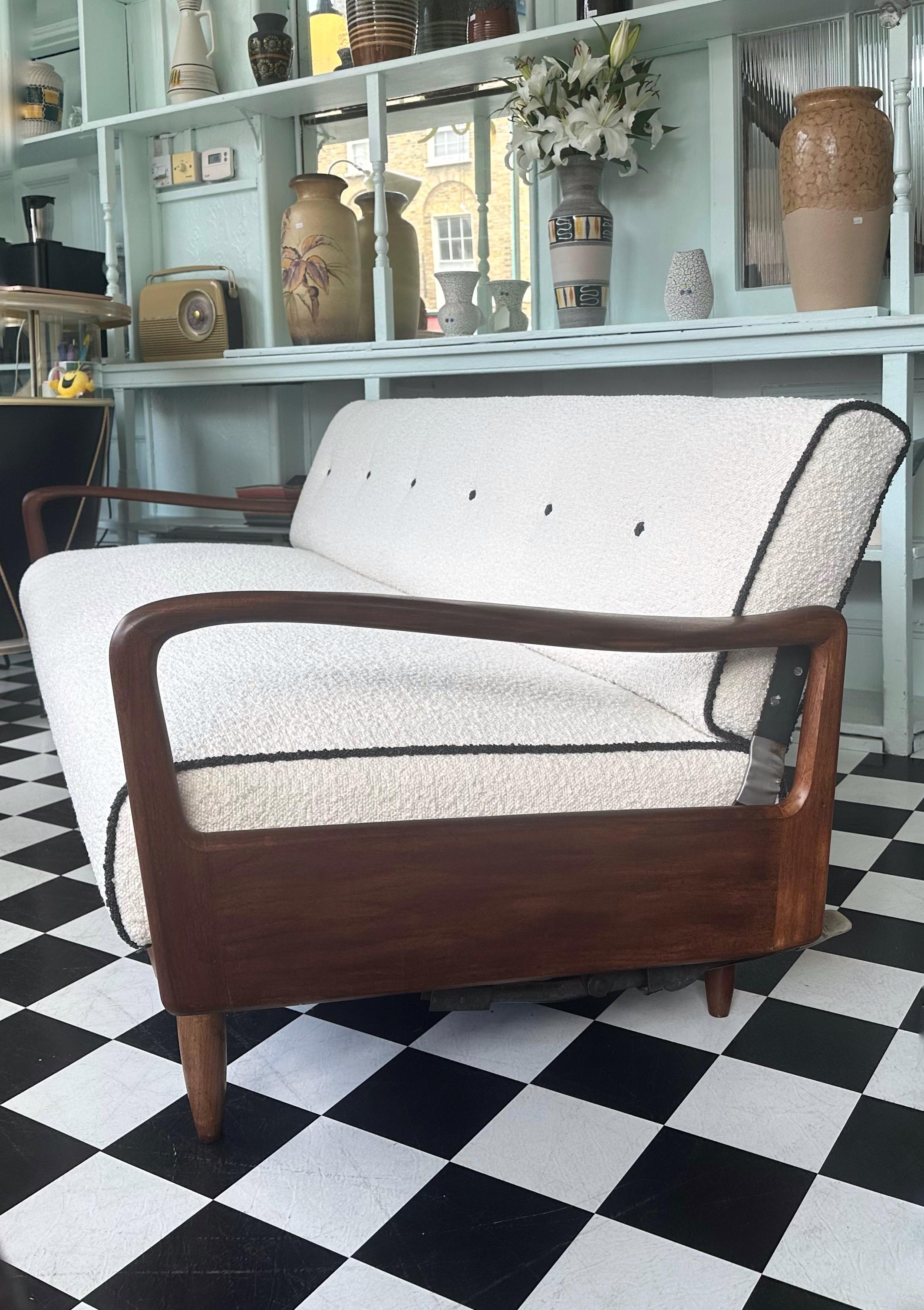 This stunning mid-century sofa bed was manufactured in 1960s by renowned British company Greaves and Thomas. Beautifully designed with sculptured armrests, very comfortable sprung seats and stylish solid teak tapered legs. Has been fully