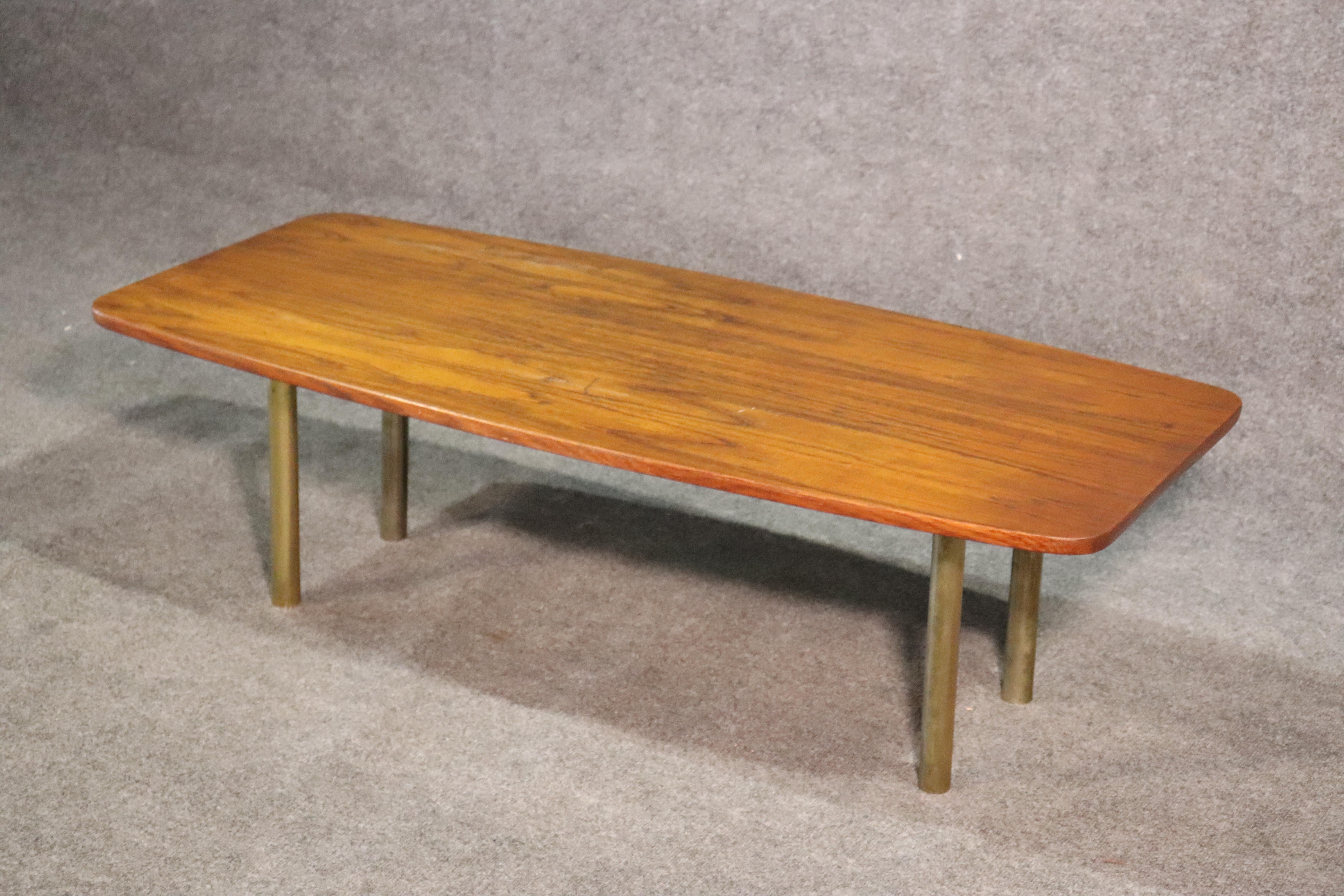 This is a sleek solid teak Hugo Troeds coffee table made in Sweden during the 1950s. Measures: 47 wide x 14/75 tall x 22.25 wide.