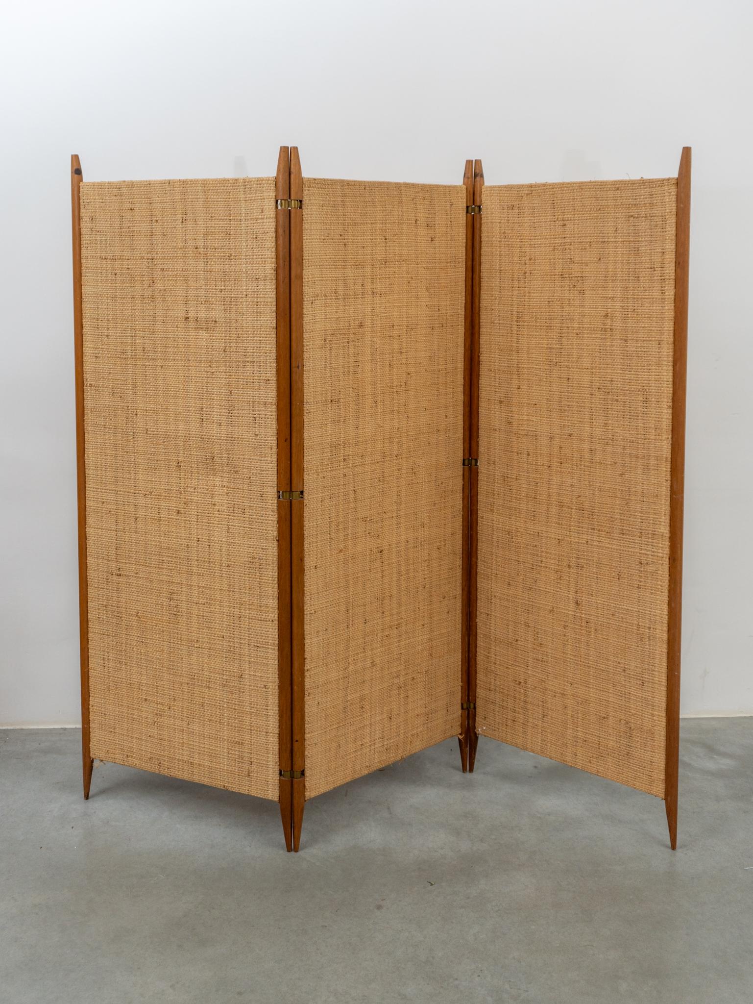 Beautiful original handcrafted in cane woven screen divided into three panels connected to six teak uprights finished with brass hinged elements that can place the room divider in all possible positions. A Beautiful piece for your living-room or