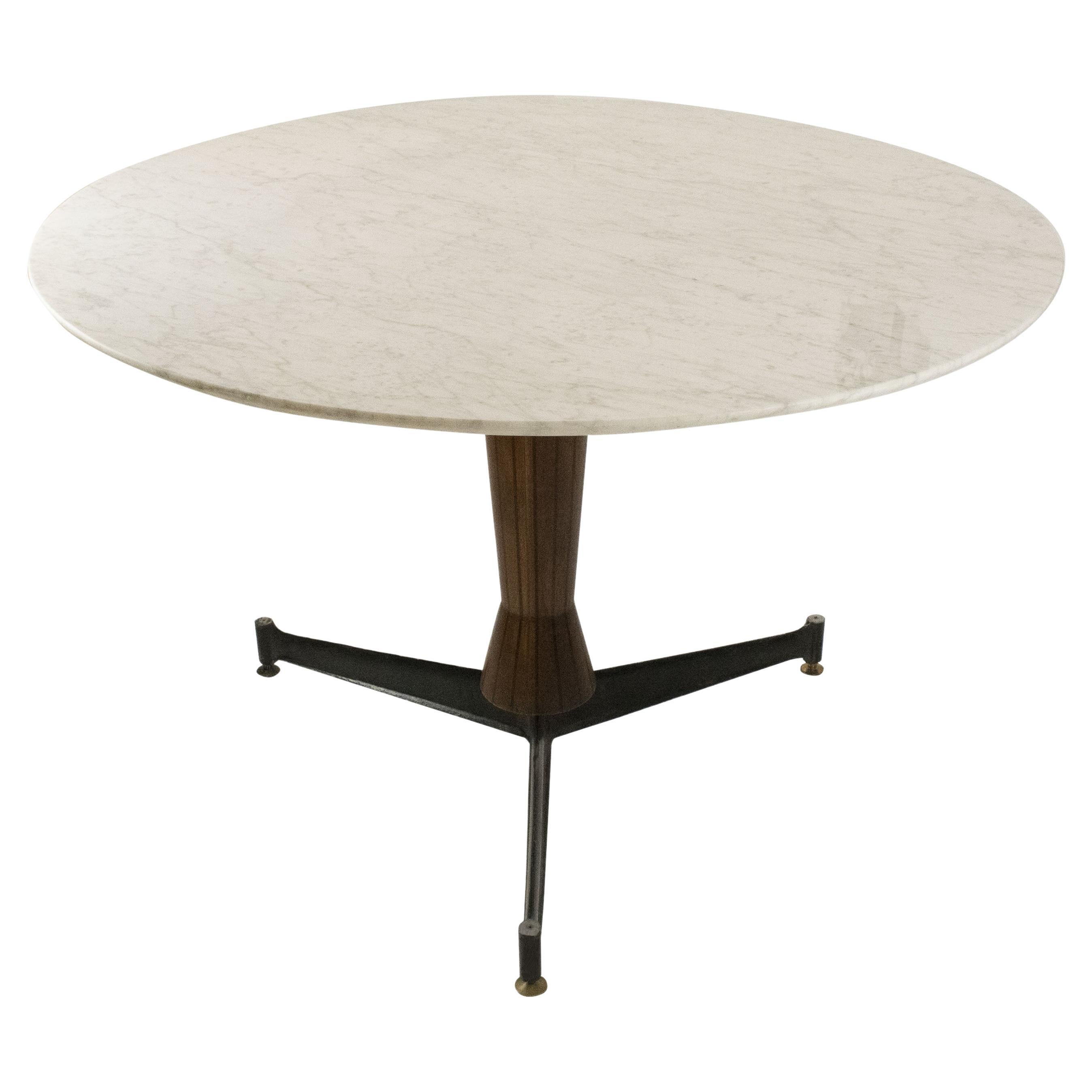 Mid-century round dining table with white Carrara marble top and teak wood foot decorated with black stripes and black lacquered metal supports finished in height-adjustable brass pads.
Measurements: 
Base width: 13 cm diameter
Base height: 74 cm.