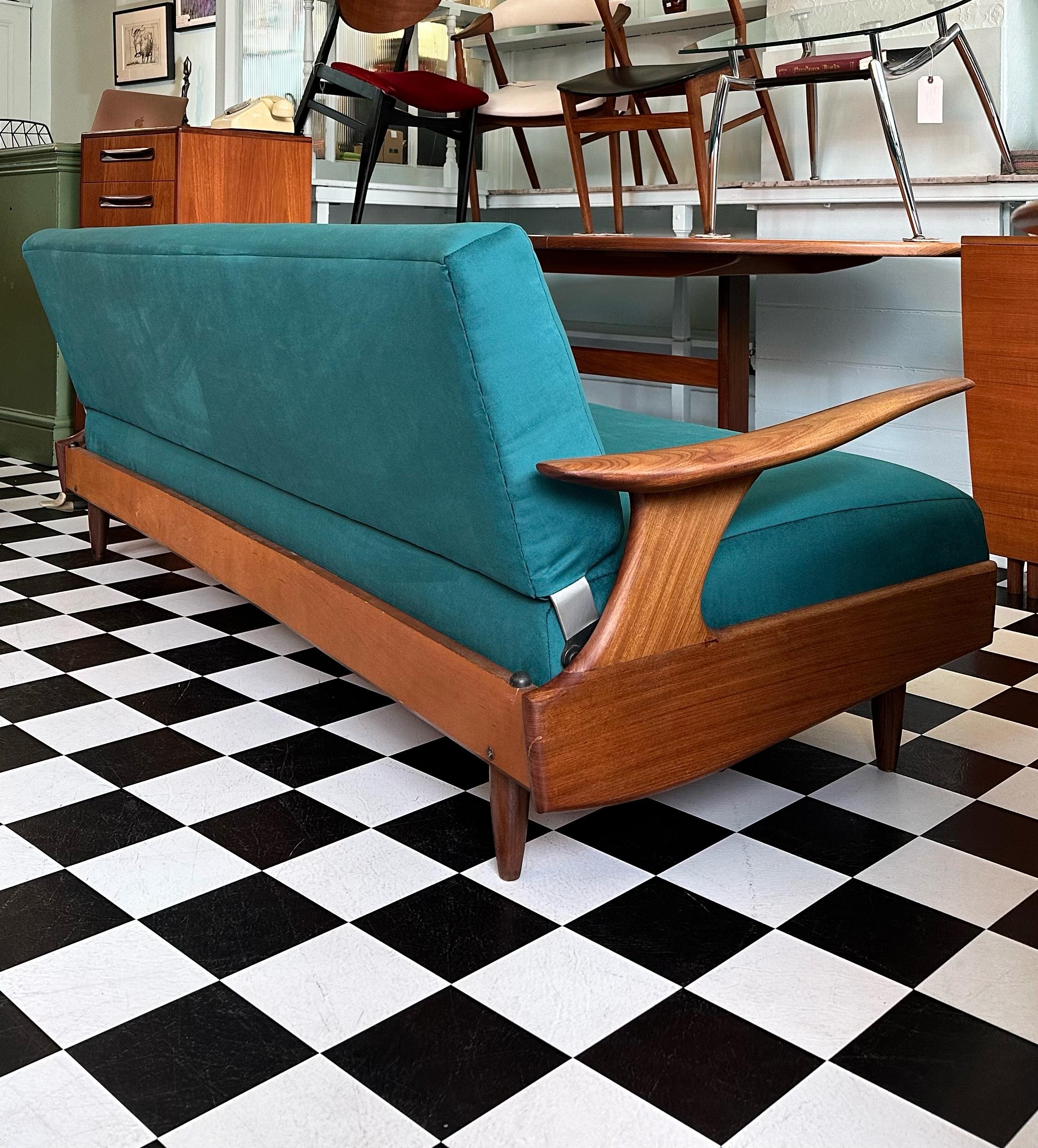 This stunning mid-century sofa bed was manufactured in 1960s by renowned British company Greaves and Thomas. Beautifully designed with curved floating armrests, very comfortable sprung seats and stylish solid teak tapered legs. Has been fully