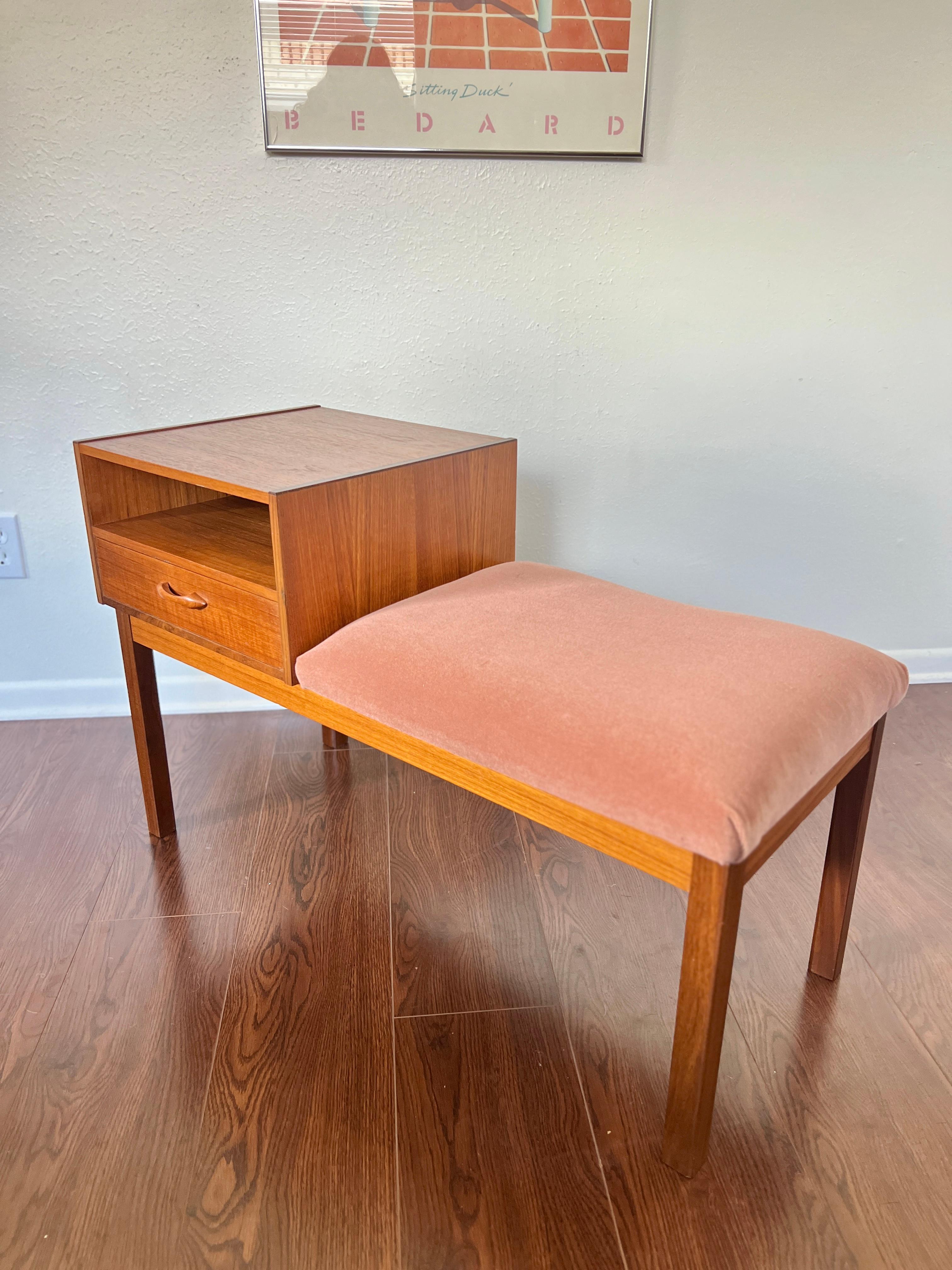 This mid century modern telephone bench circa 1960s has a wonderful design and minimalist feel. Newly refinished and reupholstered in a pink mohair. Perfect for an entryway or in the living room as a lamp table. In very good condition.