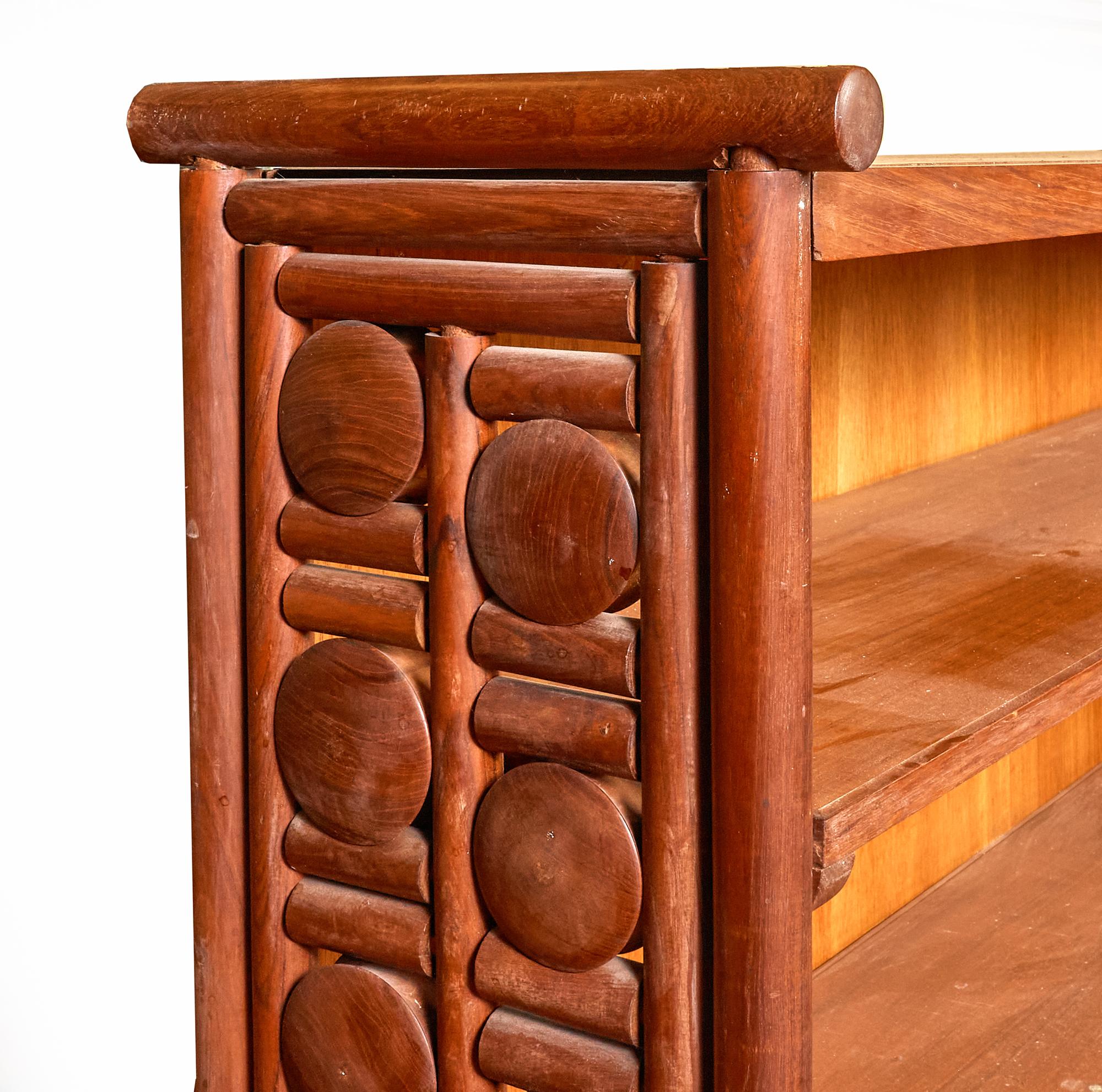 Rare and unique handcrafted solid teak Mid-Century Modern book case with floating disk design. The intricately designed sides are a series of teak disks and bars which allows the disks to turn freely while being held in place without nails. This