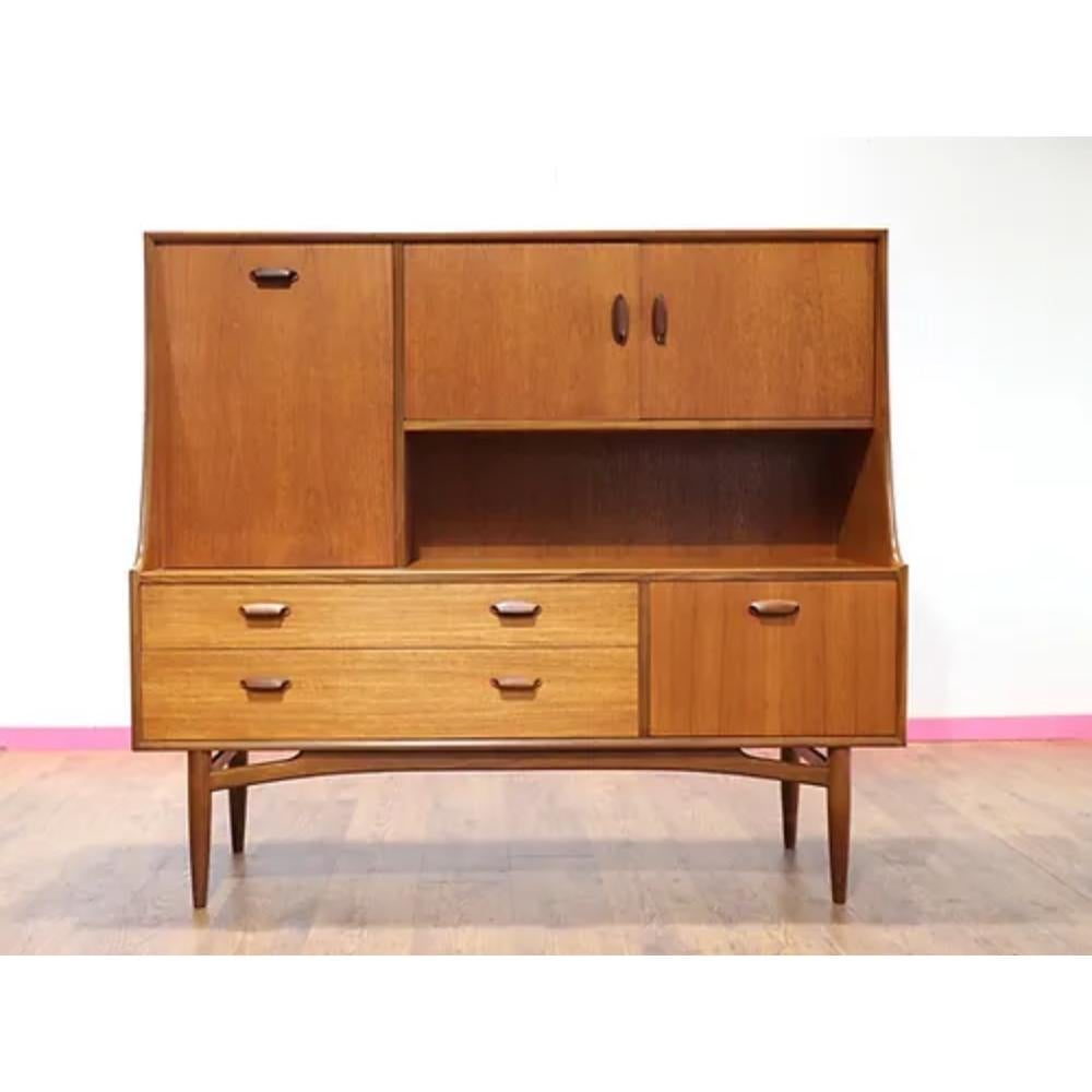 Introducing the Mid Century Modern Teak Brasilia Sideboard Tall Credenza Buffet by G Plan, a stunning piece from the iconic Brasilia range. Crafted by the renowned British cabinet maker, G Plan, this tall credenza exudes timeless style and