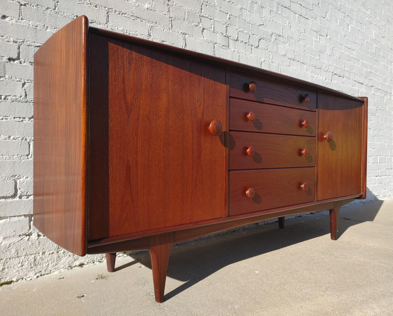 Mid Century Modern Teak Buffet by Younger

Above average vintage condition and structurally sound. Has some expected slight finish wear and scratching.
Additional information:
Materials: Teak
Vintage from the 1960s
Dimensions: 66  W x 19  D x 32 H in