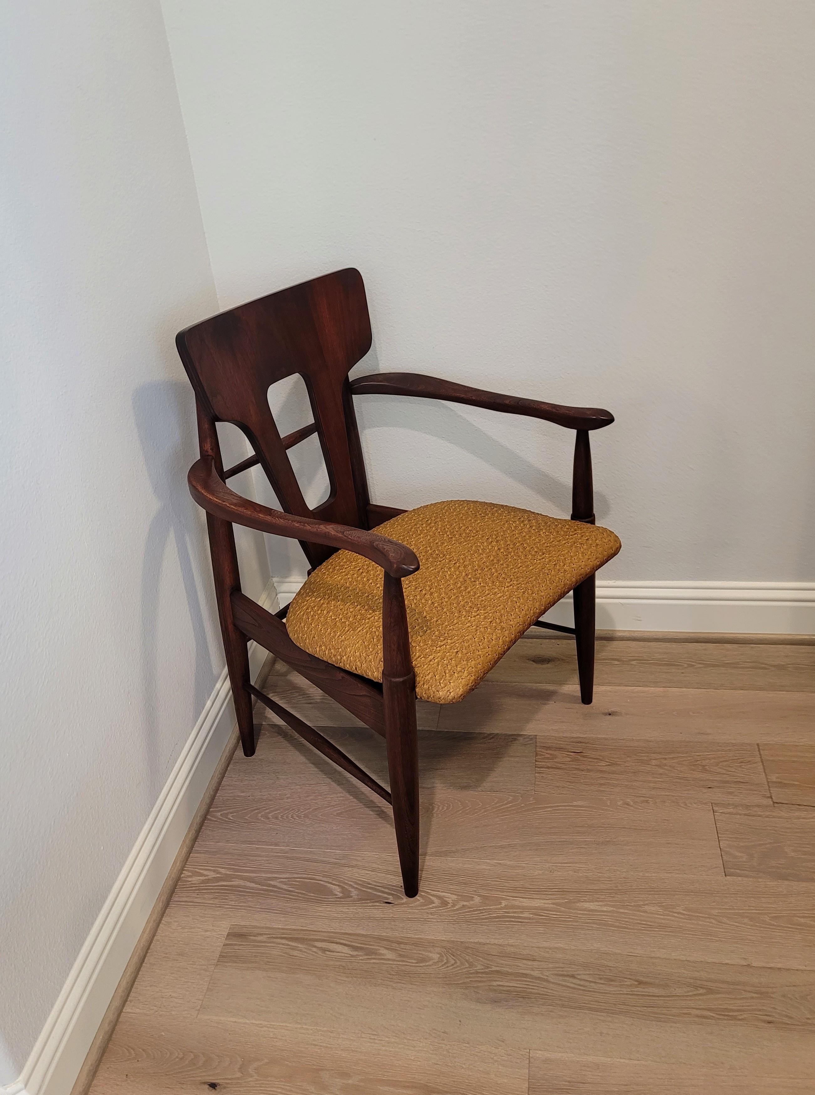 A fabulous 1960s Mid-Century Modern sculptural armchair in dark teakwood and tan ostrich upholstery. 

A bit wider and more substantial than typical Scandinavian Modern chairs, having a distinctive sculptural Silhouette that is both comfortable