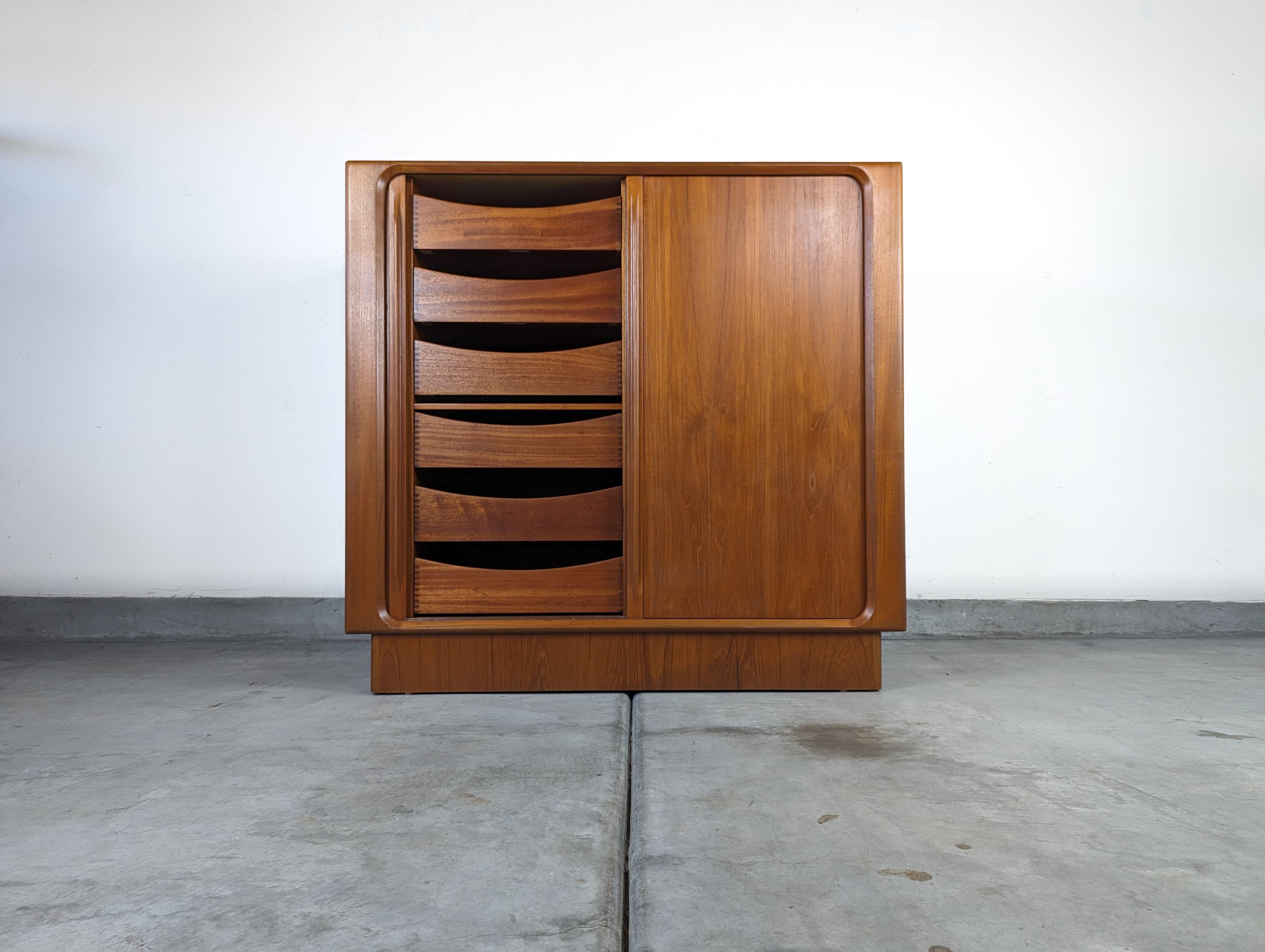 Step into the world of timeless elegance with this exquisite vintage mid-century Danish modern Tambour Door Chest, crafted by the esteemed Bernhard Pedersen & Son in the 1960s. This magnificent piece showcases the sleek, clean lines and functional