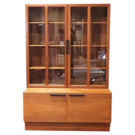 A wall unit by Ib Kofod-Larsen for Faarup Møbelfabrik from Denmark 1960s. This unit consists of two elements that are not connected; a display cabinet and a cabinet with two drawers. The display cabinet has two doors with glass and black metal