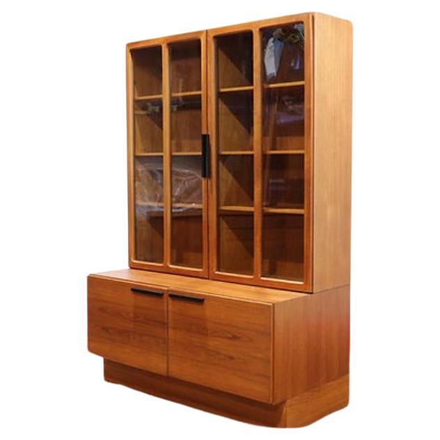 A wall unit by Ib Kofod-Larsen for Faarup Møbelfabrik from Denmark 1960s. This unit consists of two elements that are not connected; a display cabinet and a cabinet with two drawers. The display cabinet has two doors with glass and black metal