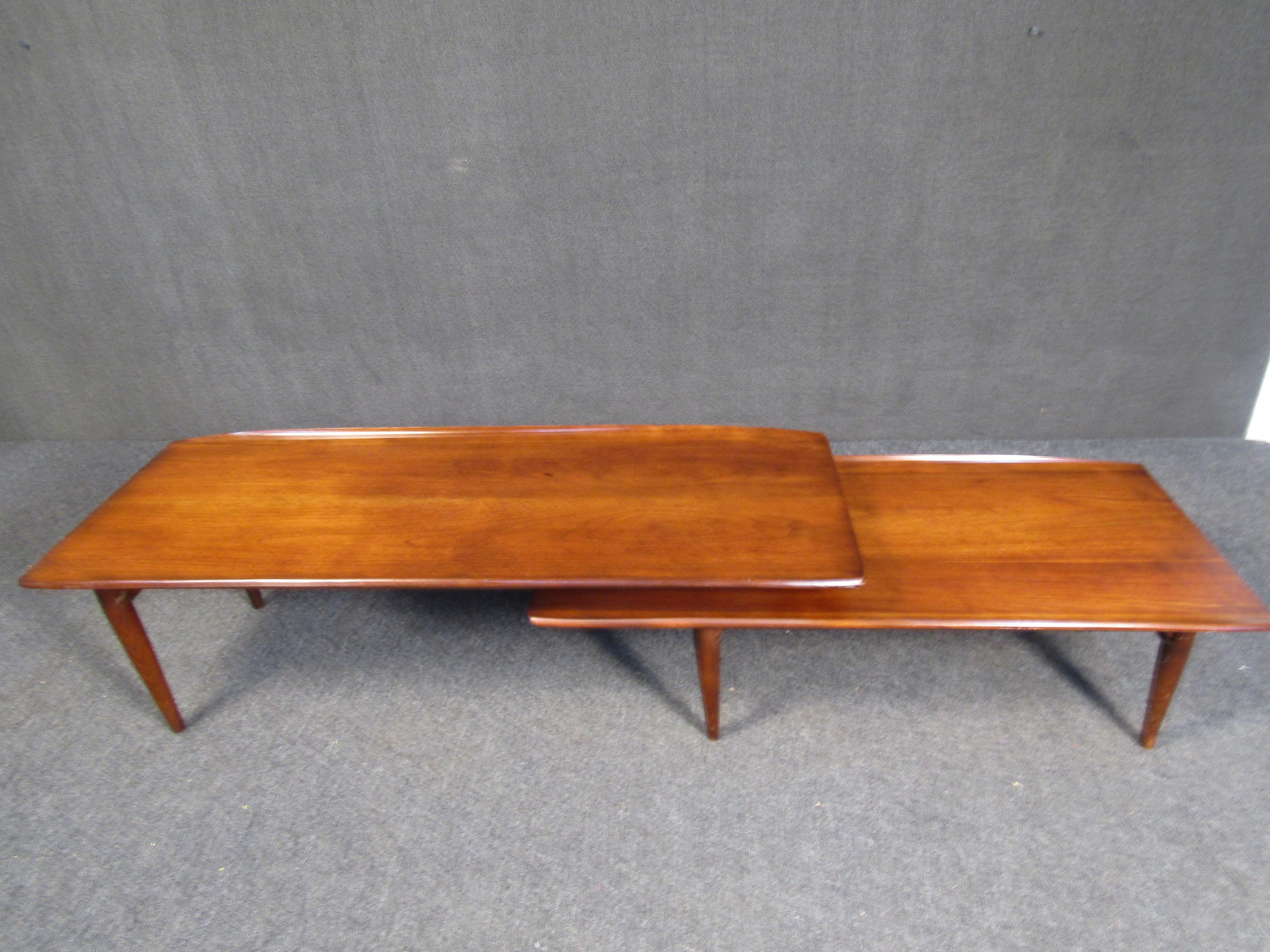 With a unique adjustable design, this two-tiered coffee table can be rearranged to work in different settings. Handsome teak woodgrain makes this piece perfect for adding Mid-Century style to any interior. Please confirm item location with seller