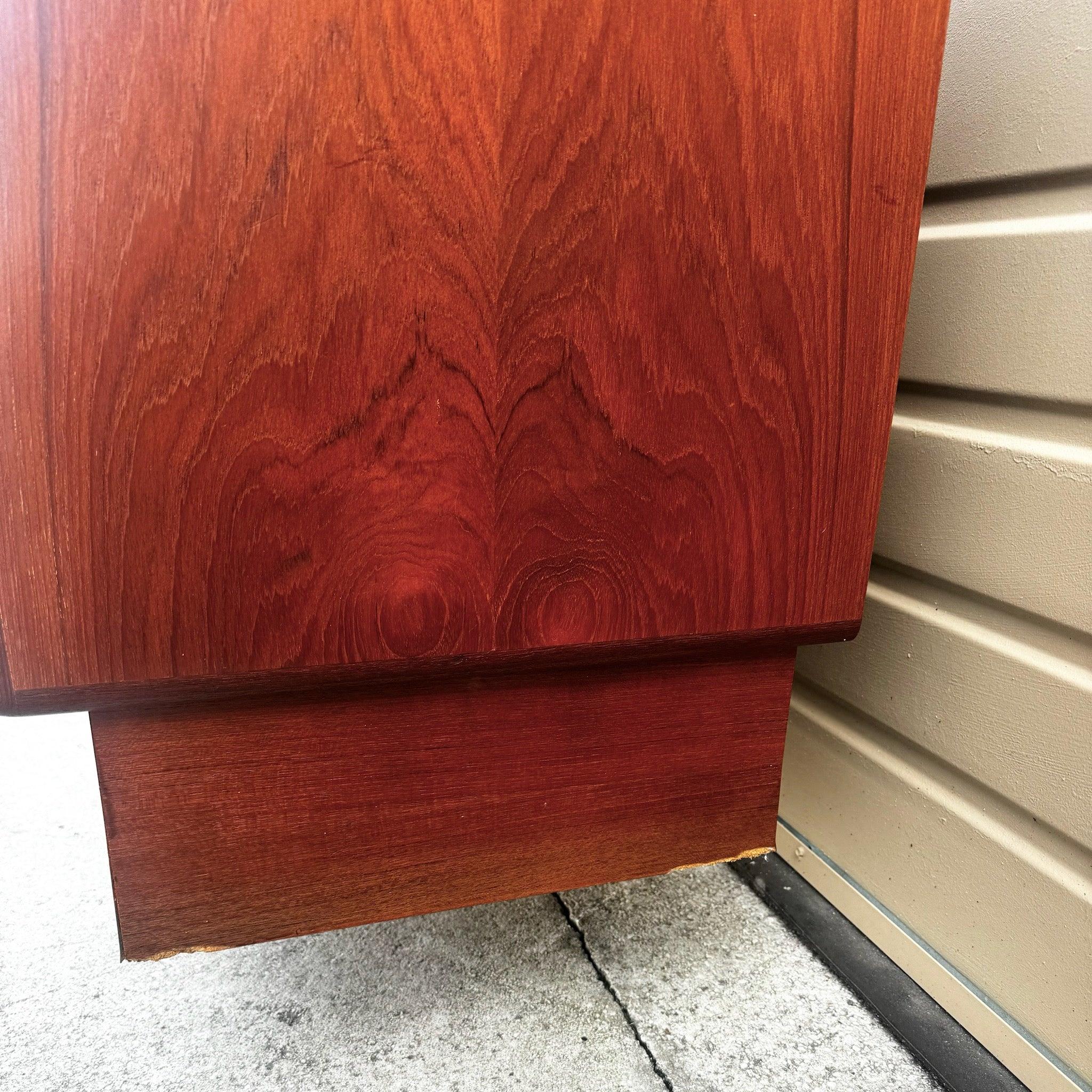 Credenza in teak moderna del Mid-Century caratterizzata da un design elegante, ricche venature del legno e un ampio spazio di archiviazione con armadi e cassetti.
 
 Alcuni segni di scolorimento intorno alla base, come mostrato nelle foto. Minima