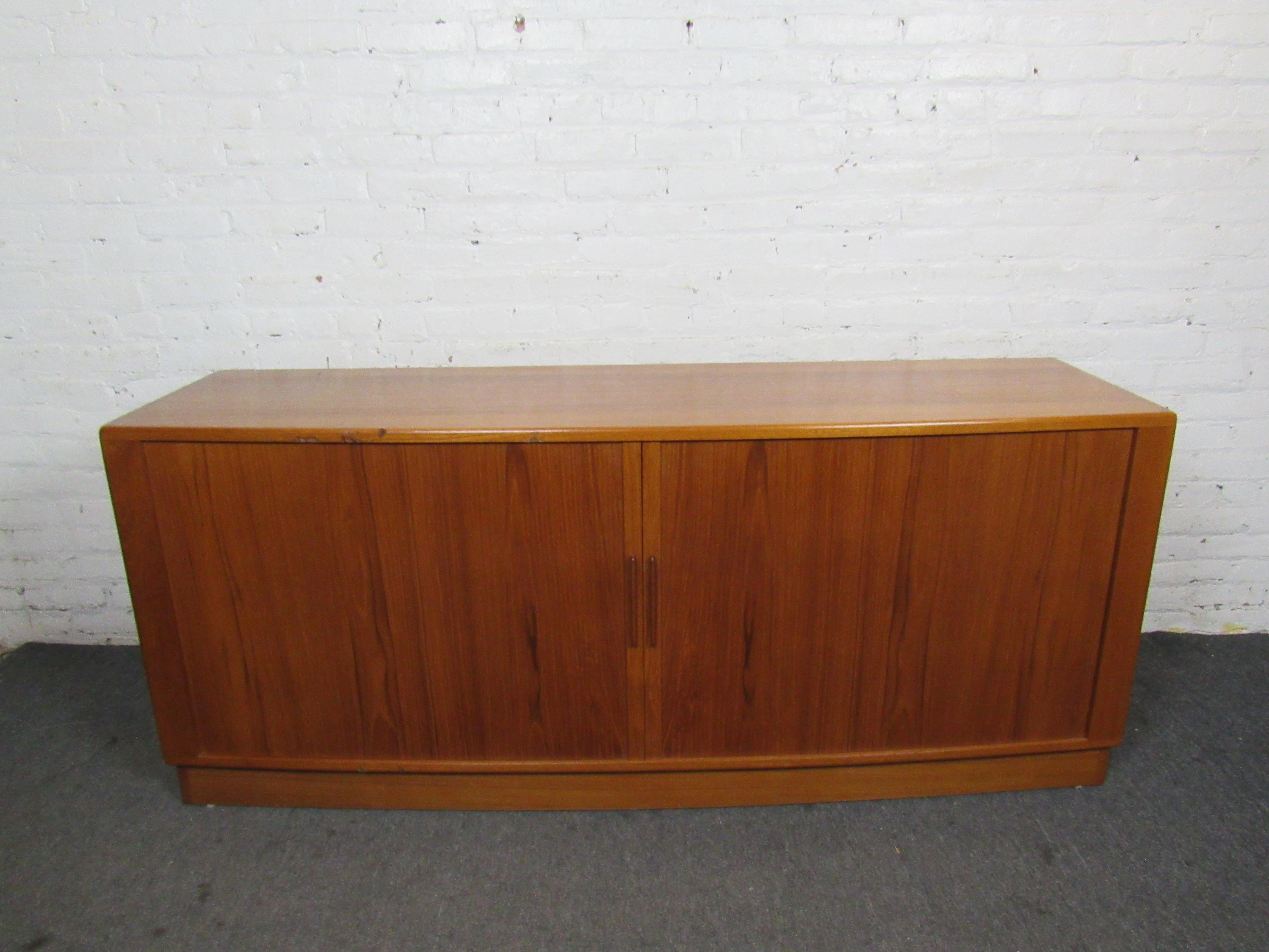 This large Mid-Century Modern credenza offers plenty of storage behind sliding doors and a clean understated design. Teak wood and quality craftsmanship make it a beautiful investment for any home or office. 
Please confirm item location with