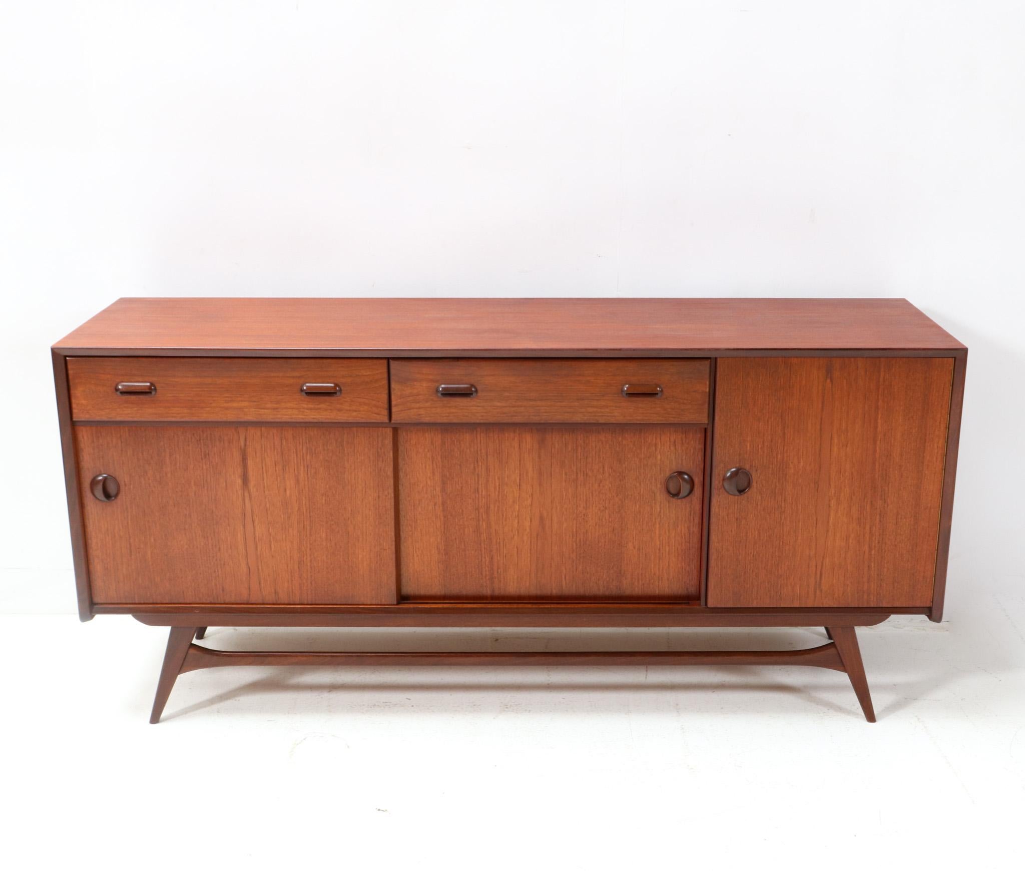 Magnificent and ultra rare Mid-Century Modern credenza or sideboard.
Design by Louis van Teeffelen for WéBé.
Striking Dutch design from the 1950s.
Organic shaped base in solid teak and original teak veneer.
The top is original and veneered with