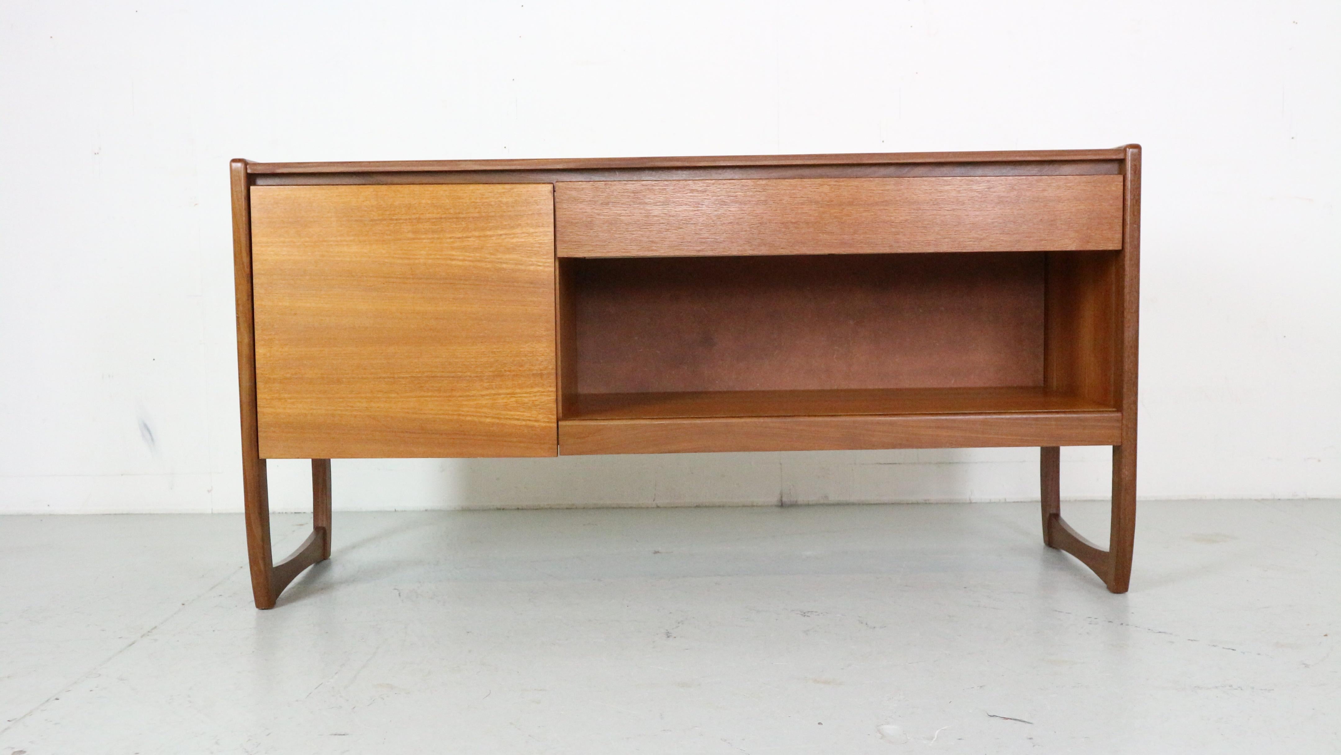 Mid- Century modern period lovely sideboard

In a good vintage condition due to it's age and use.
This  sideboard is made of teak veneer and solid round elegant frame.
Pull up drawer and a cabinet for a perfect record storage.

It has been