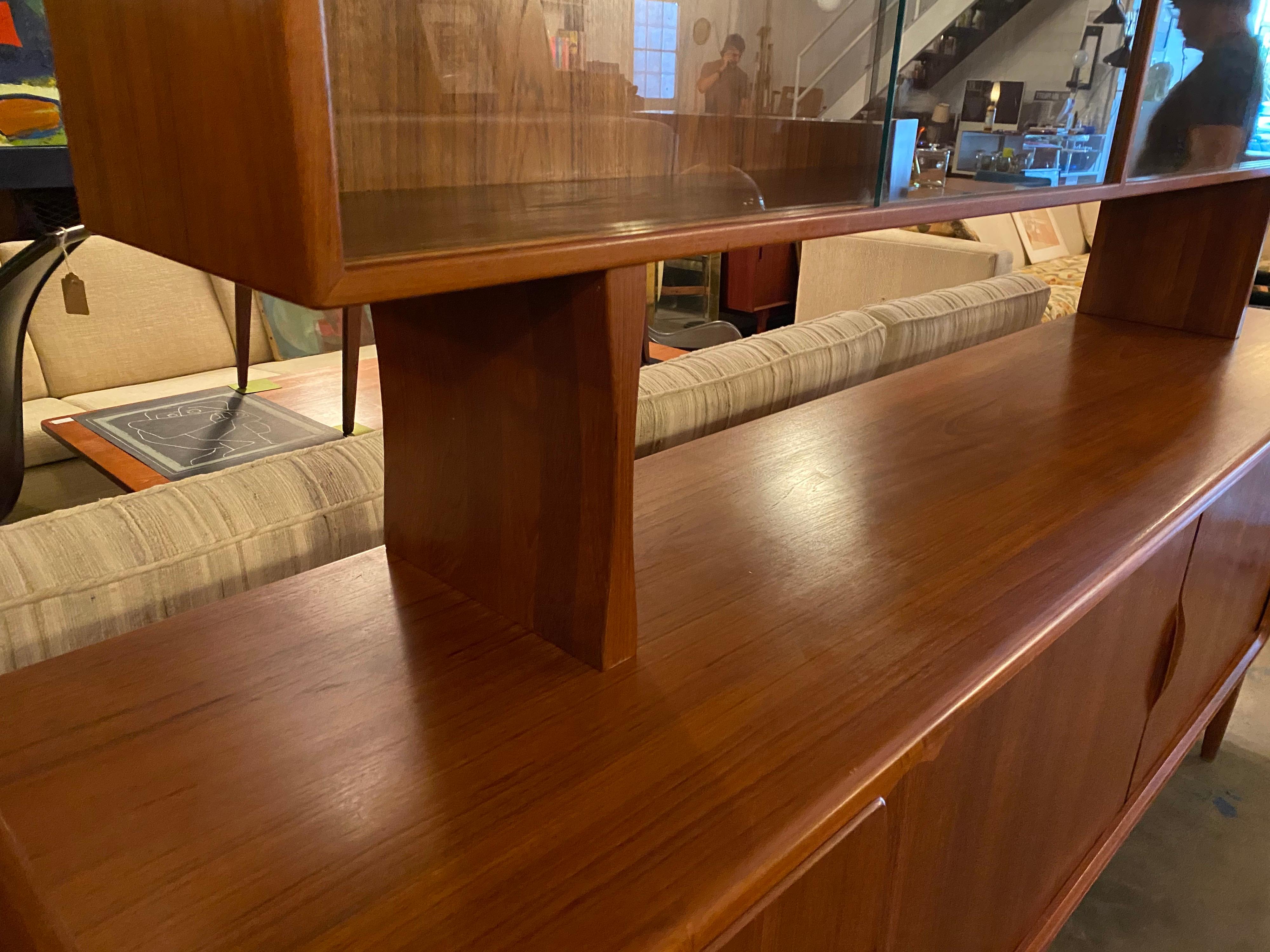 Beautiful vintage Danish modern teak credenza with removable hutch is designed by Johannes Andersen. With smooth lines, finished back, and sculpted handles the tambour doors open up to plenty of shelving as well as pull out drawers lined with felt,