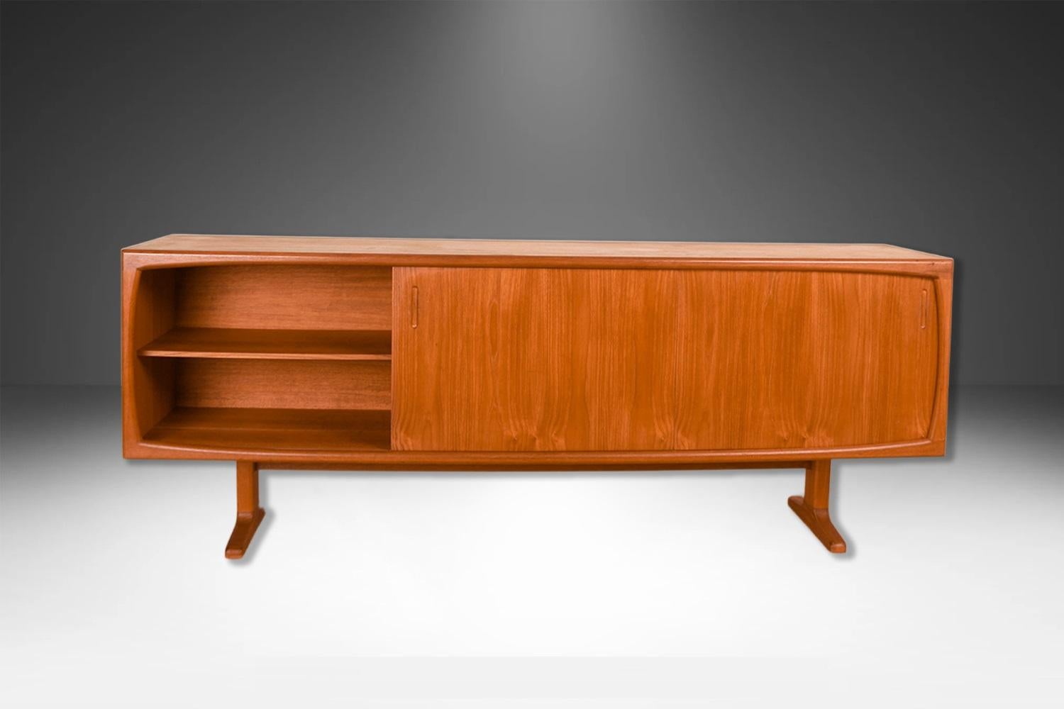 Una bellissima credenza/seduta danese in teak della metà del secolo scorso. Questo pezzo è lungo, basso e semplicemente stupendo! Realizzato con precisione in un eccezionale legno con venature di teak, con uno schienale completamente rifinito. Il