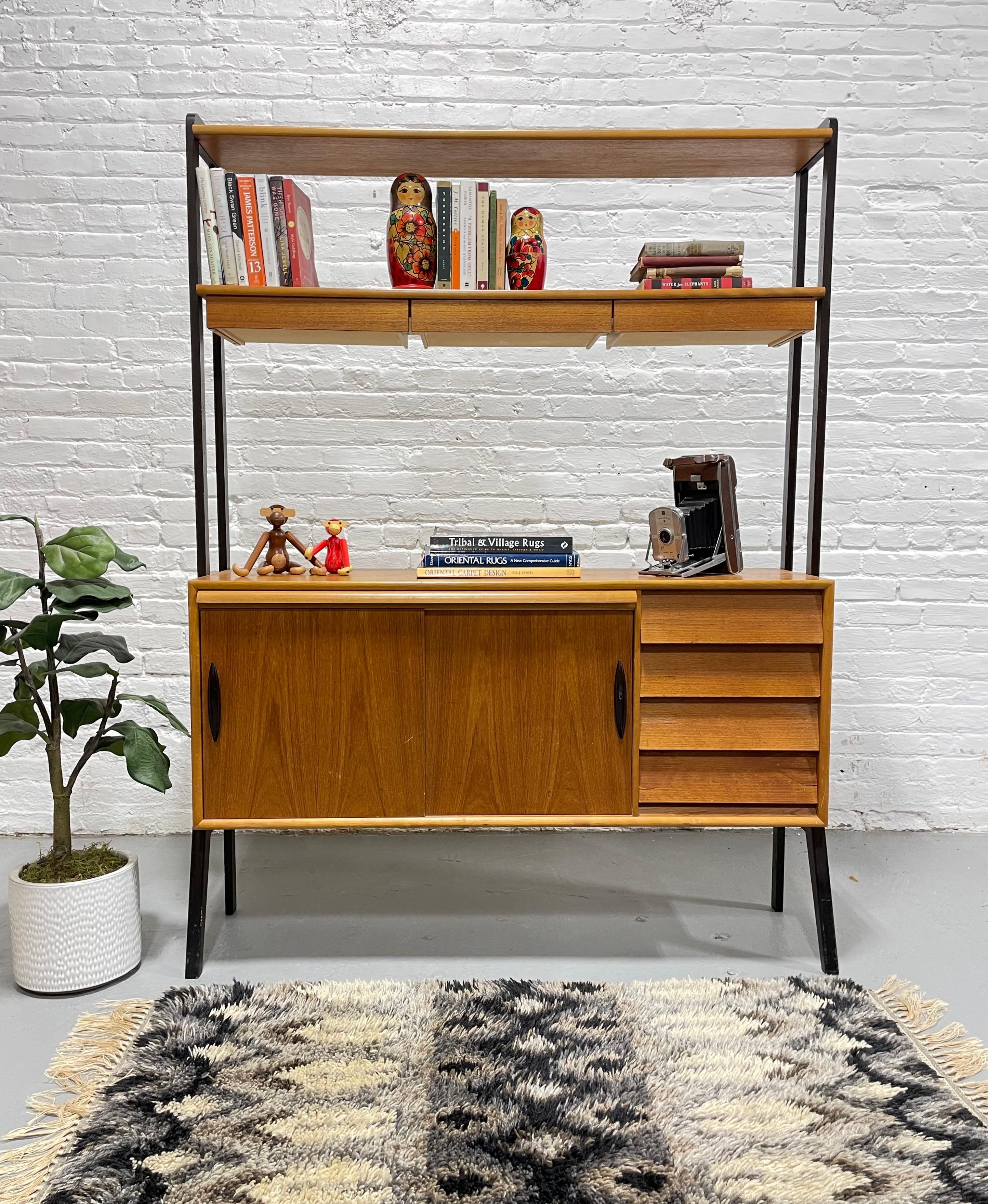 Mid Century Modern Danish Teak Bookcase with Hidden Pull Out Desk, c. 1960's. This gorgeous piece features a lower cabinet with a long shelf and four drawers.  The bookcase has a pull out desk, perfect for working on your laptop. You will also find