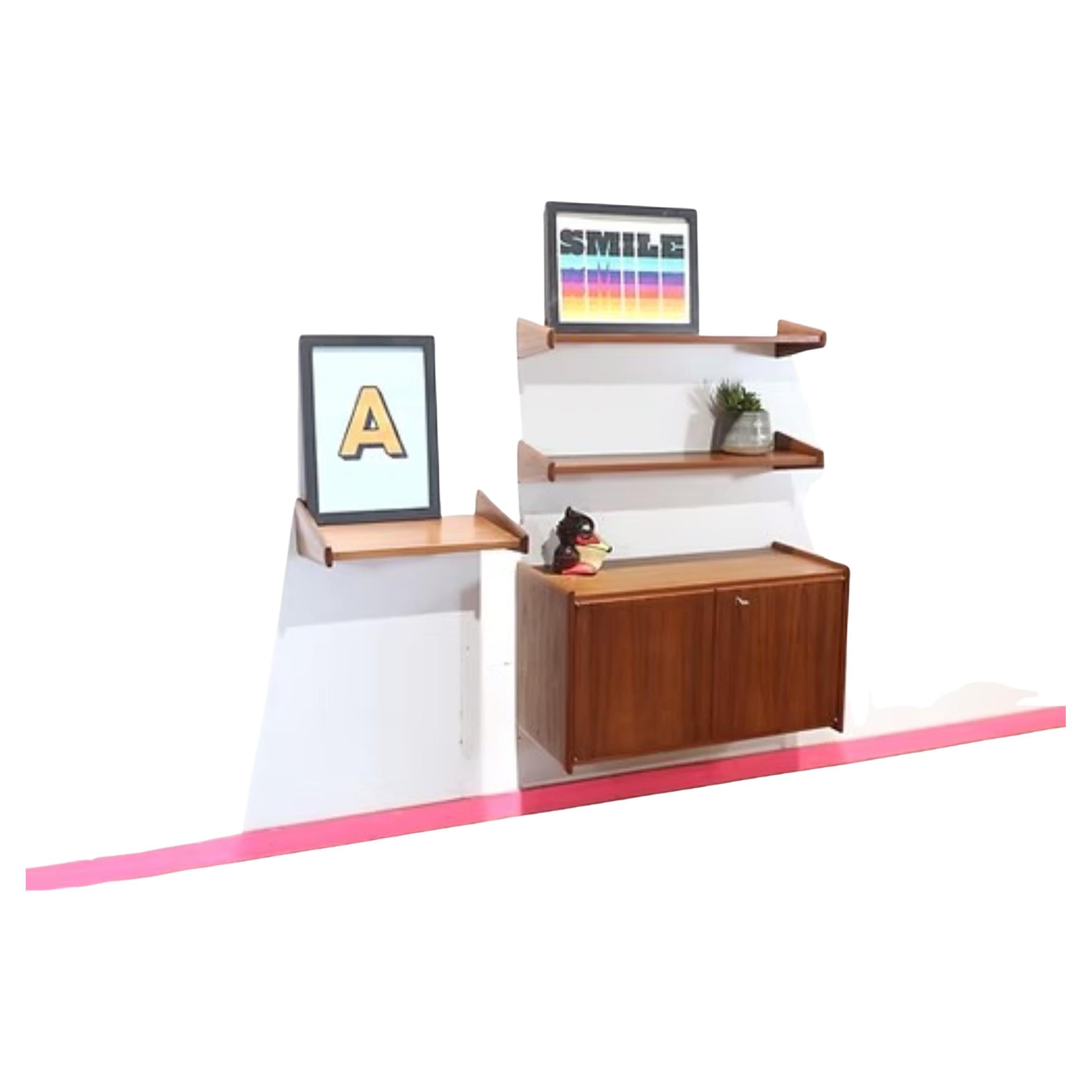 Scopri l'eleganza di questo appendiabiti in teak in stile danese. Un sistema a parete sospeso di grande effetto, con un mobile e delle mensole, che fonde perfettamente funzionalità e design senza tempo. Perfetto per mettere in mostra i tuoi oggetti