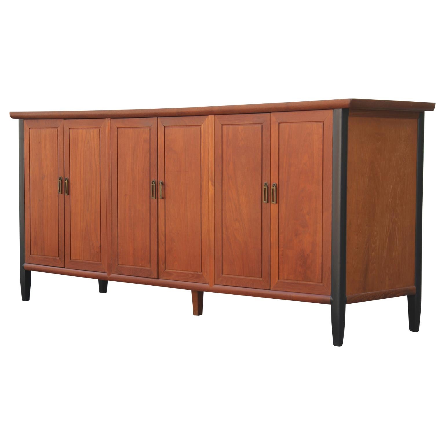 Mid-Century Modern teak Danish sideboard that opens to reveal three sections, each containing removable shelves and two drawers in the center.