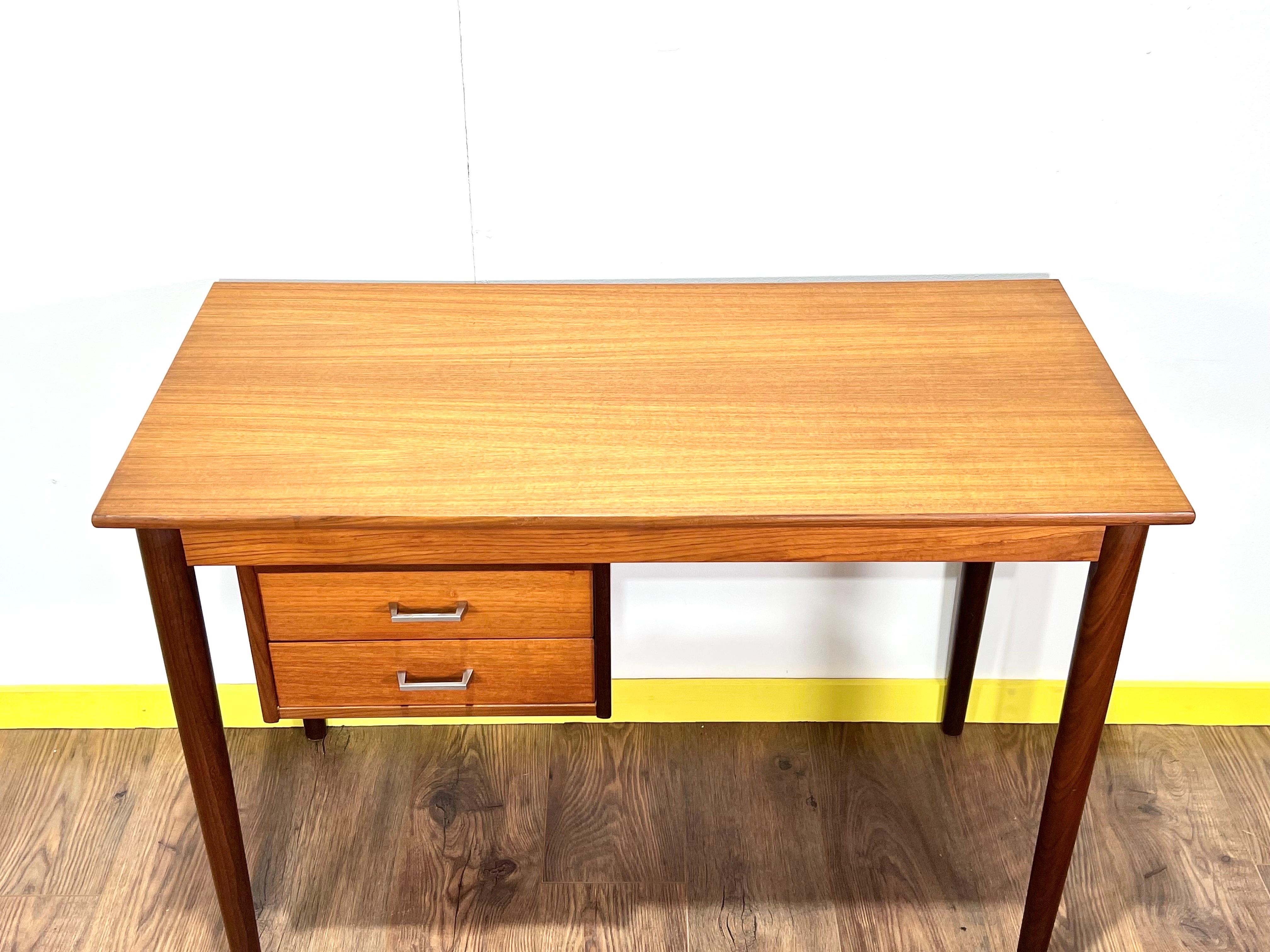 This gorgeous mid century writing desk by Vi Ma Moblet is fantastic piece of Danish minimalist furniture. Featuring a fantastic grain, torpedo legs and two drawers which can be fixed to either side of the desk. This desk would look great adorning