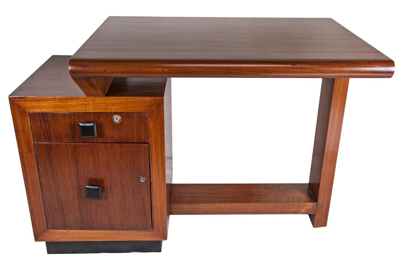 A teak wood asymmetrical desk with ebonized base and drawer pulls. Left side top drawer and cabinet below. Locks and keys for both. Lower left side is 24