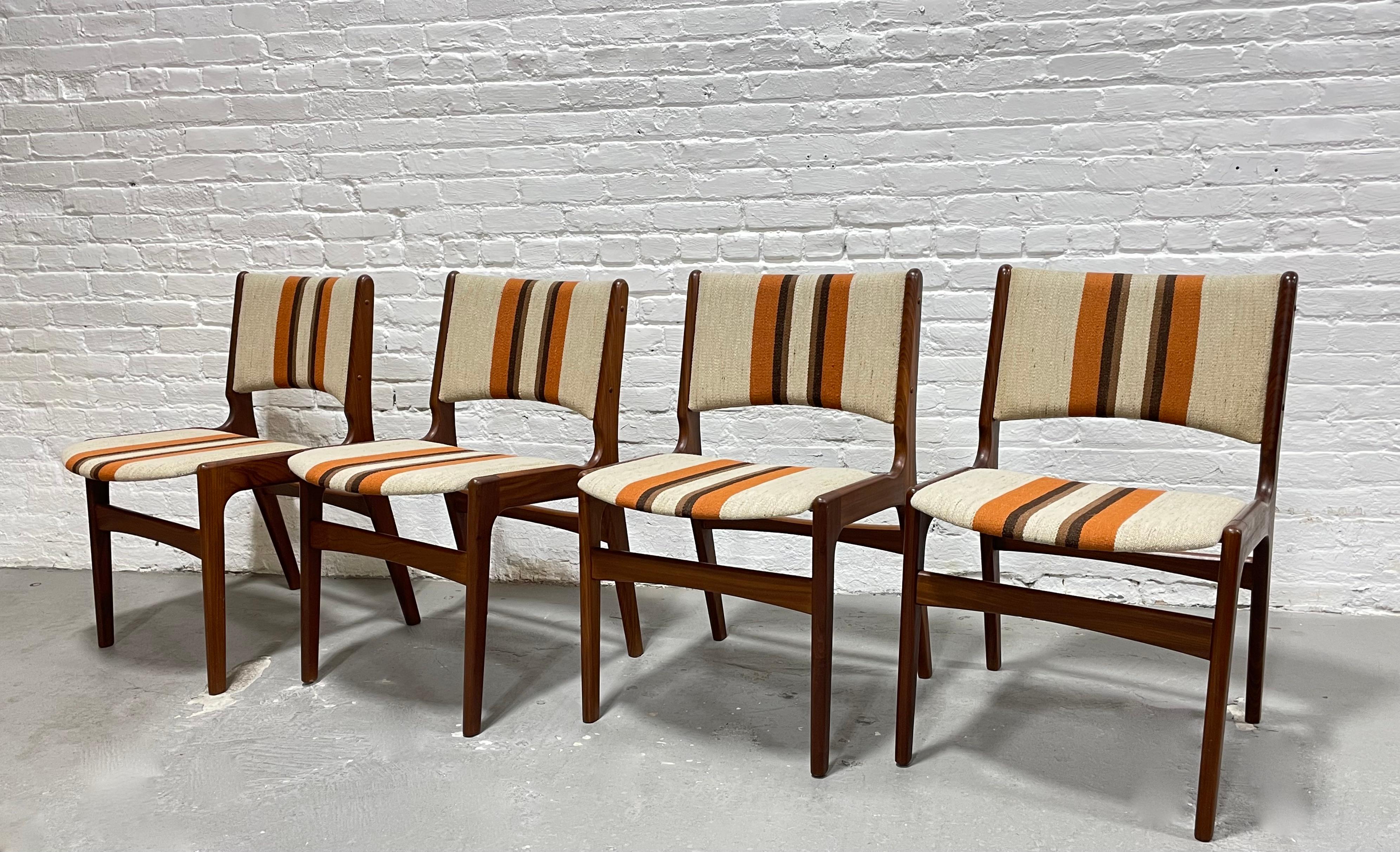 Incredible Set of Four Mid Century Modern Teak Danish Chairs by Erik Buch. This set boasts gorgeous wood grains along the teak frames and ultra comfortable support and seating. The upholstery is superb in design and condition with plush seating and