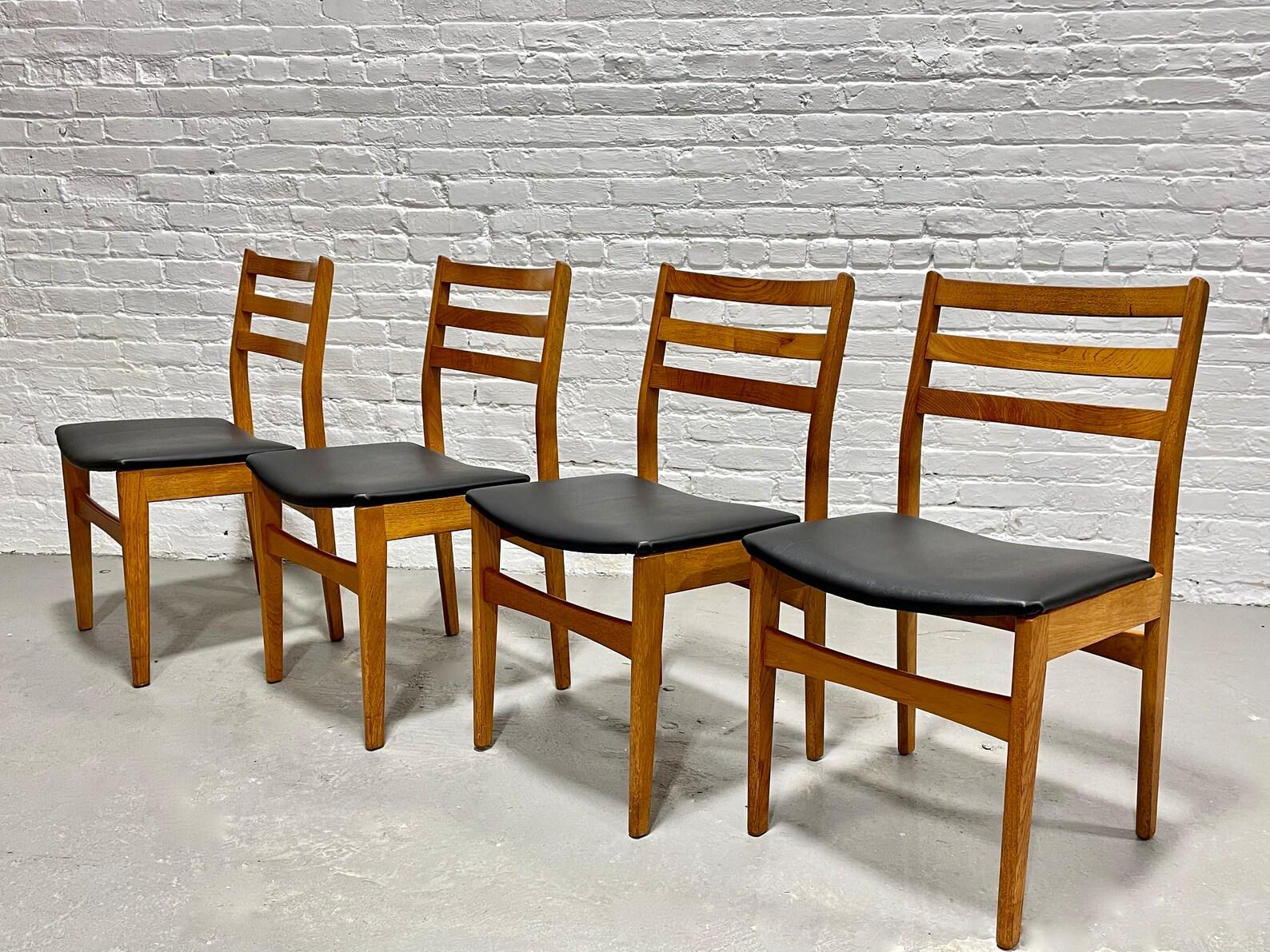 Mid Century Modern Teak Esszimmerstühle von Nordic Furniture, hergestellt in Kanada, ca. 1960.  Die Gestelle sind mit äußerst bequemen Rückenlehnen aus massivem Teakholz ausgestattet. Die Stühle wurden neu mit schwarzem Naugahyde gepolstert, das gut