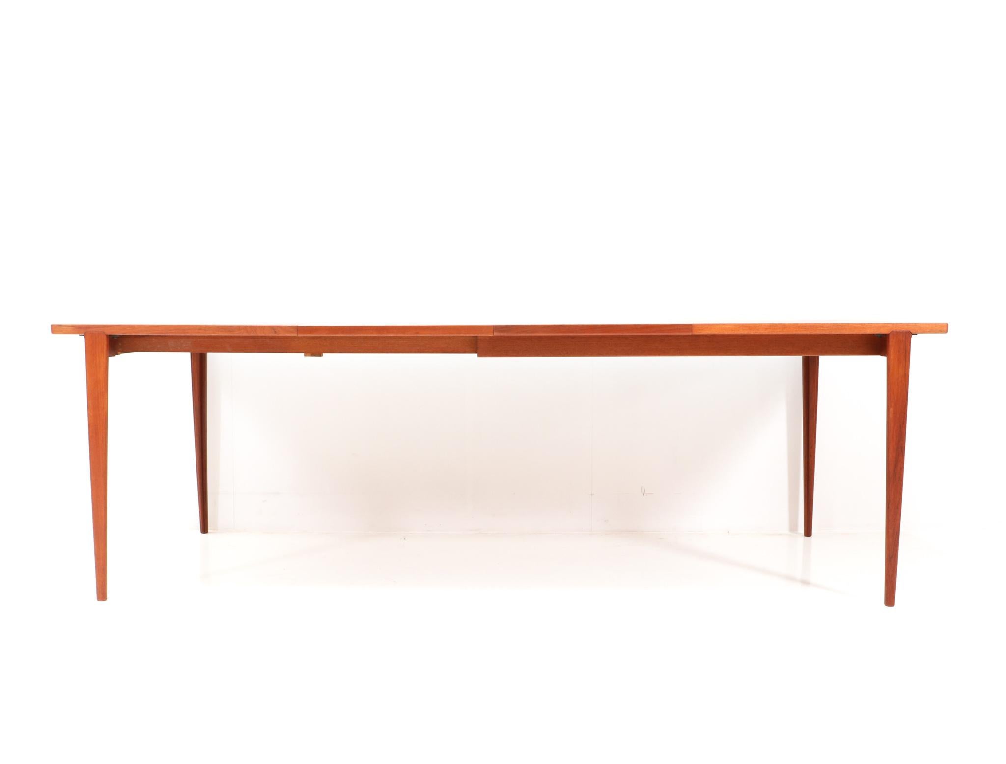 Superbe table de salle à manger de style moderne du milieu du siècle. Design/One par Henry Rosengren Hansen pour Brande Möbelindustri. Un design danois frappant des années 1960. Cadre en teck massif avec plateau d'origine en teck plaqué. Deux