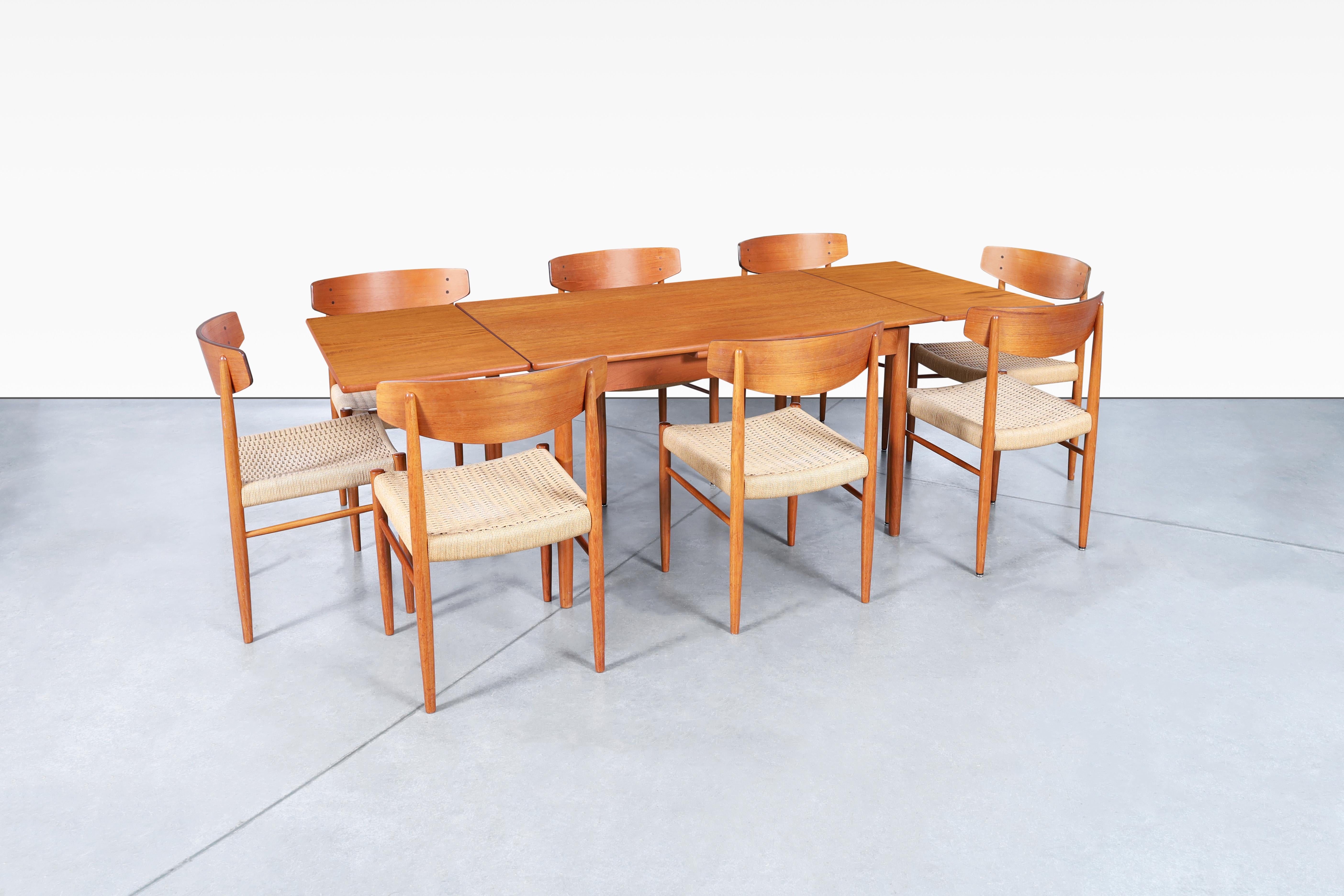 Fabulous mid-century modern teak dining set designed by AM Møbler in Denmark, circa 1960s. This dining set is a true masterpiece by an iconic manufacturer, comprising of an expanding dining table and eight dining chairs. The model 501 dining chairs