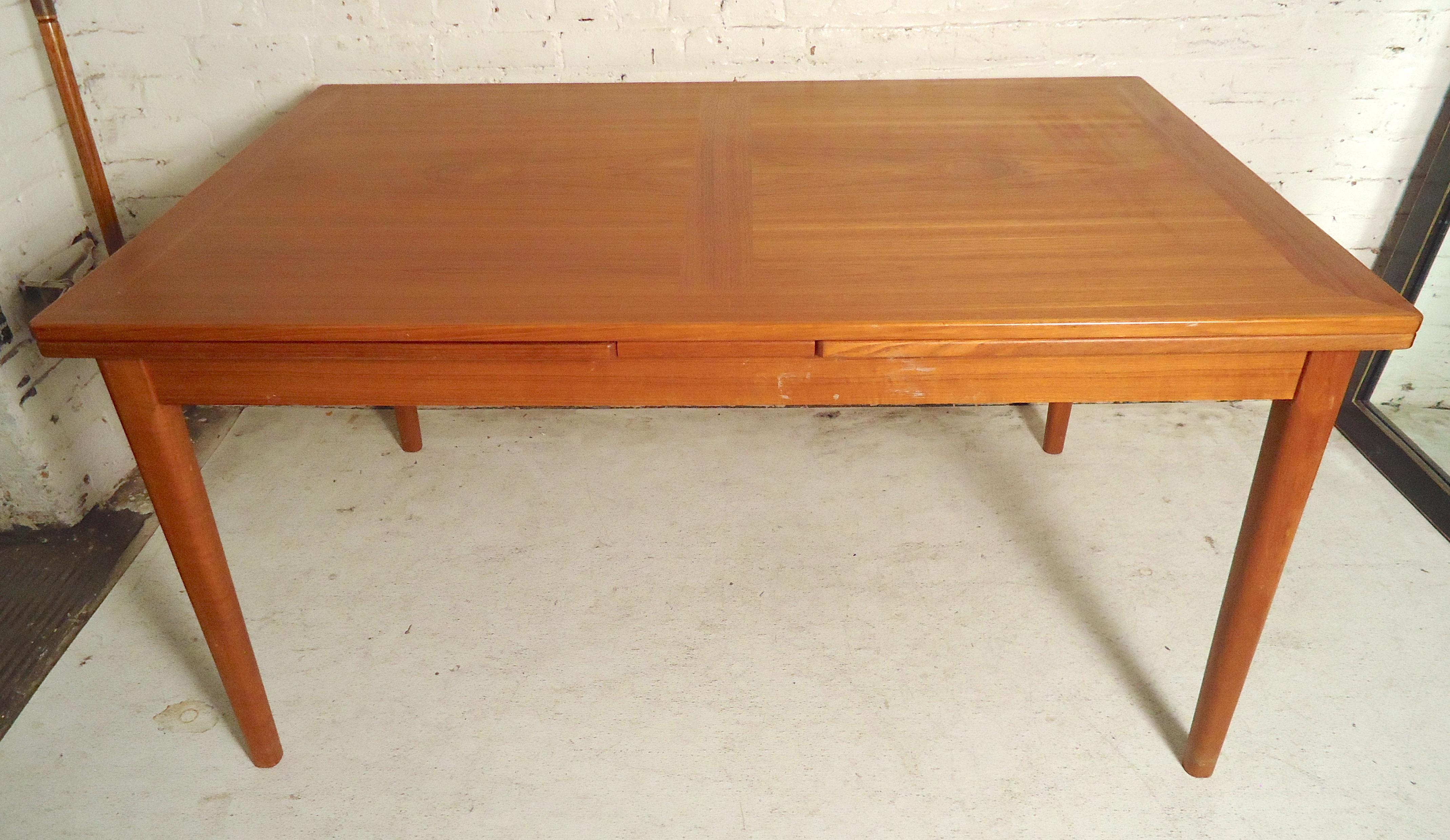 Teak dining table with two pullout / pull-out leaves. Both leaves stay under the tabletop and pullout / pull-out for four more feet of length.
Opens: 55-102