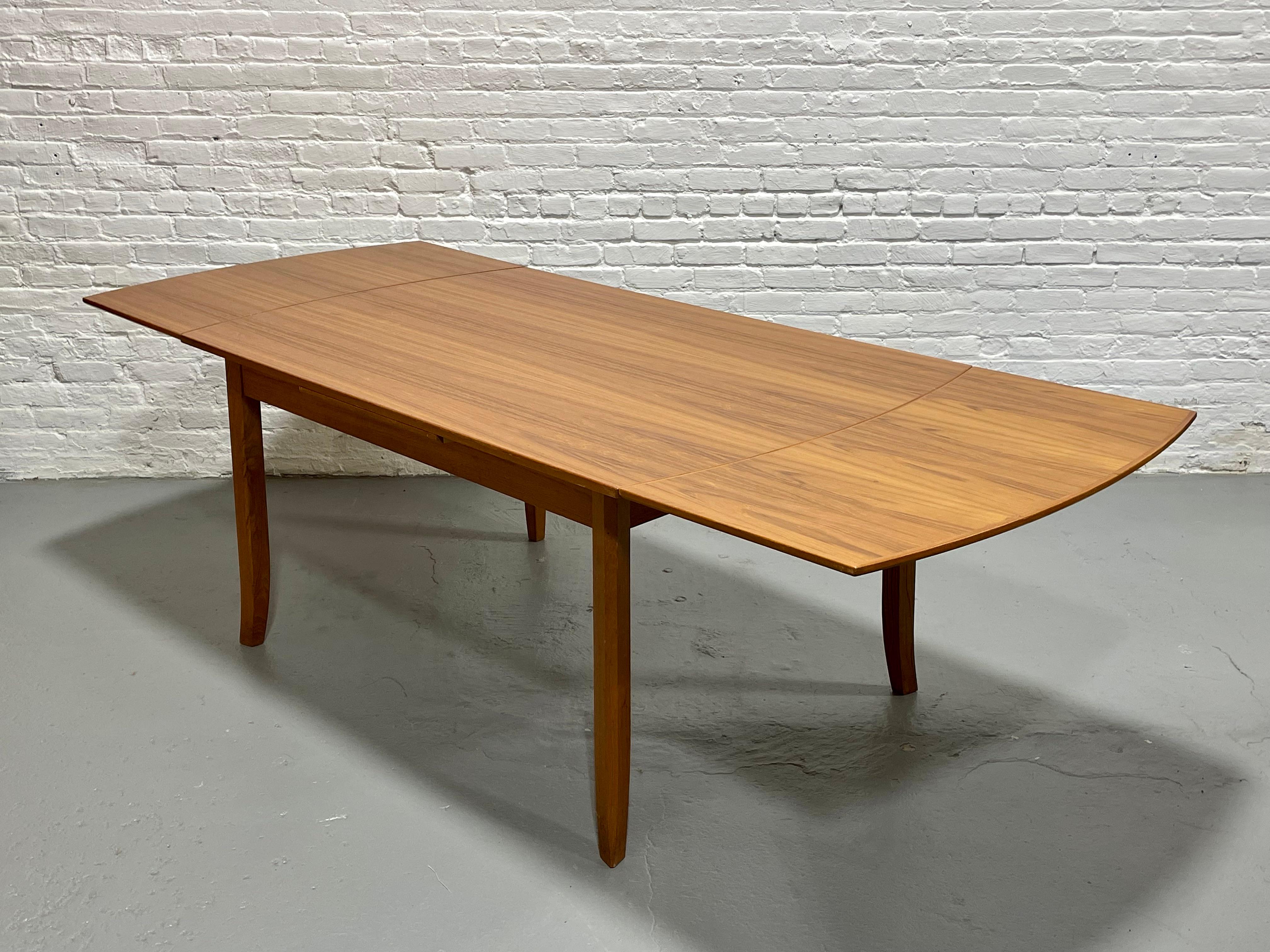 Mid Century Modern TEAK DINING TABLE with two hidden Dutch leaves, Made in Canada by Nordic Furniture, c. 1960's. The table is a perfect size as it provides for a smaller size dining table that comfortably seats 4 or 6 yet features two hidden leaves