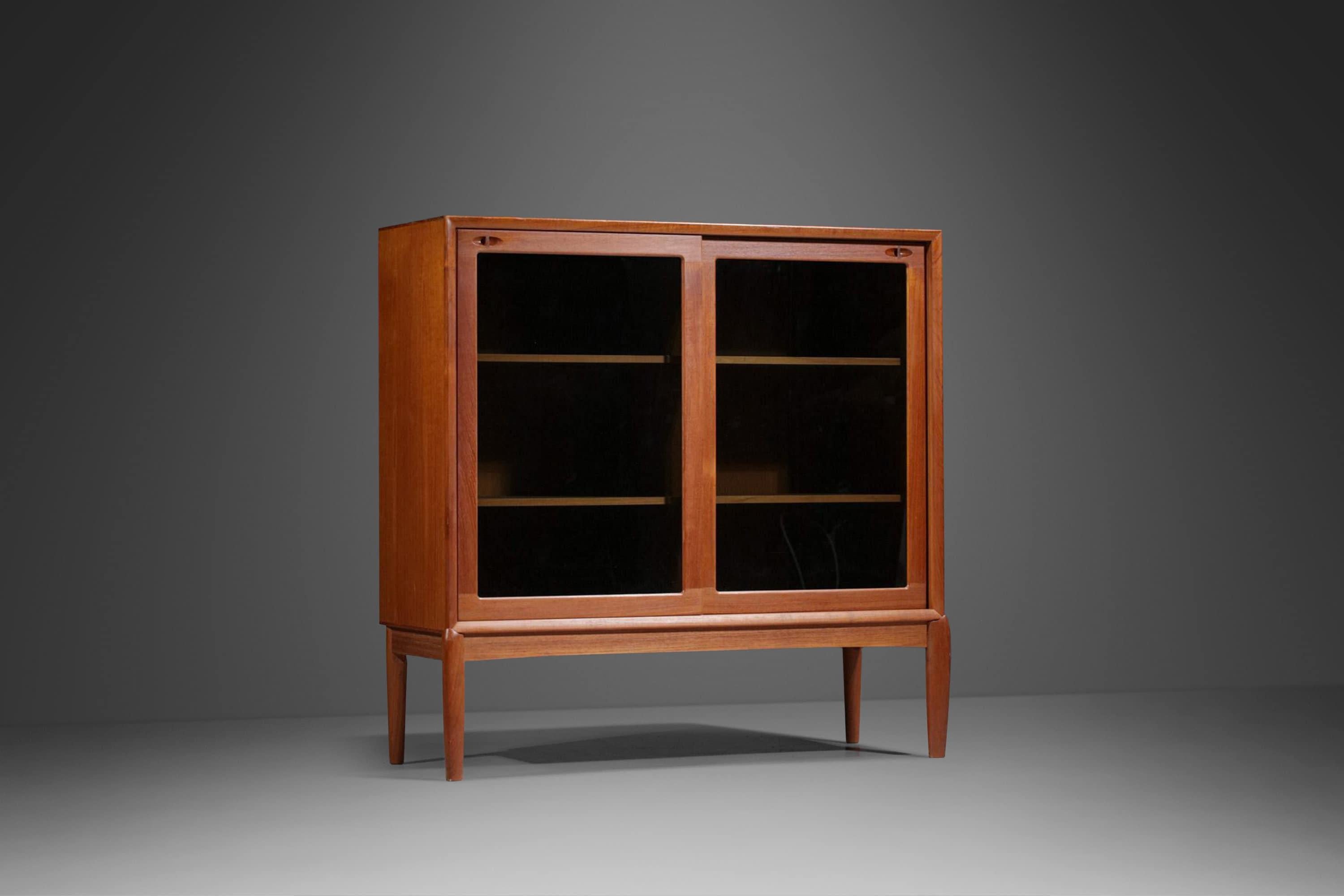 Equal parts beauty and functionality this exquisite display cabinet, designed by HW Klein for Bramin, is the epitome of functional art. Constructed mostly of solid teak with a veneered top and back featuring exceptional old-growth woodgrains this