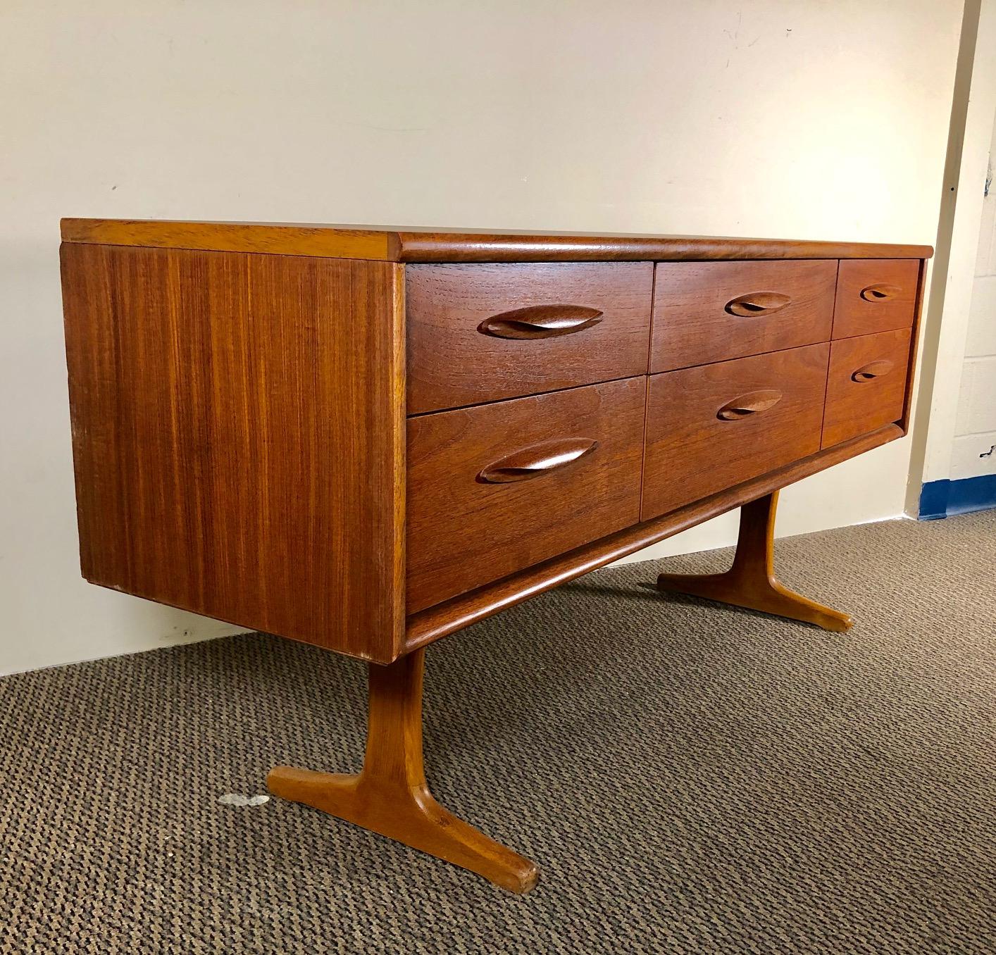 This beautiful 6 drawer dresser with was made by Austinsuite of England.

Featuring sculpted beech legs and teak handles.

Very nice vintage condition. The top was stripped and oiled at some point. The rest of the piece still has the original