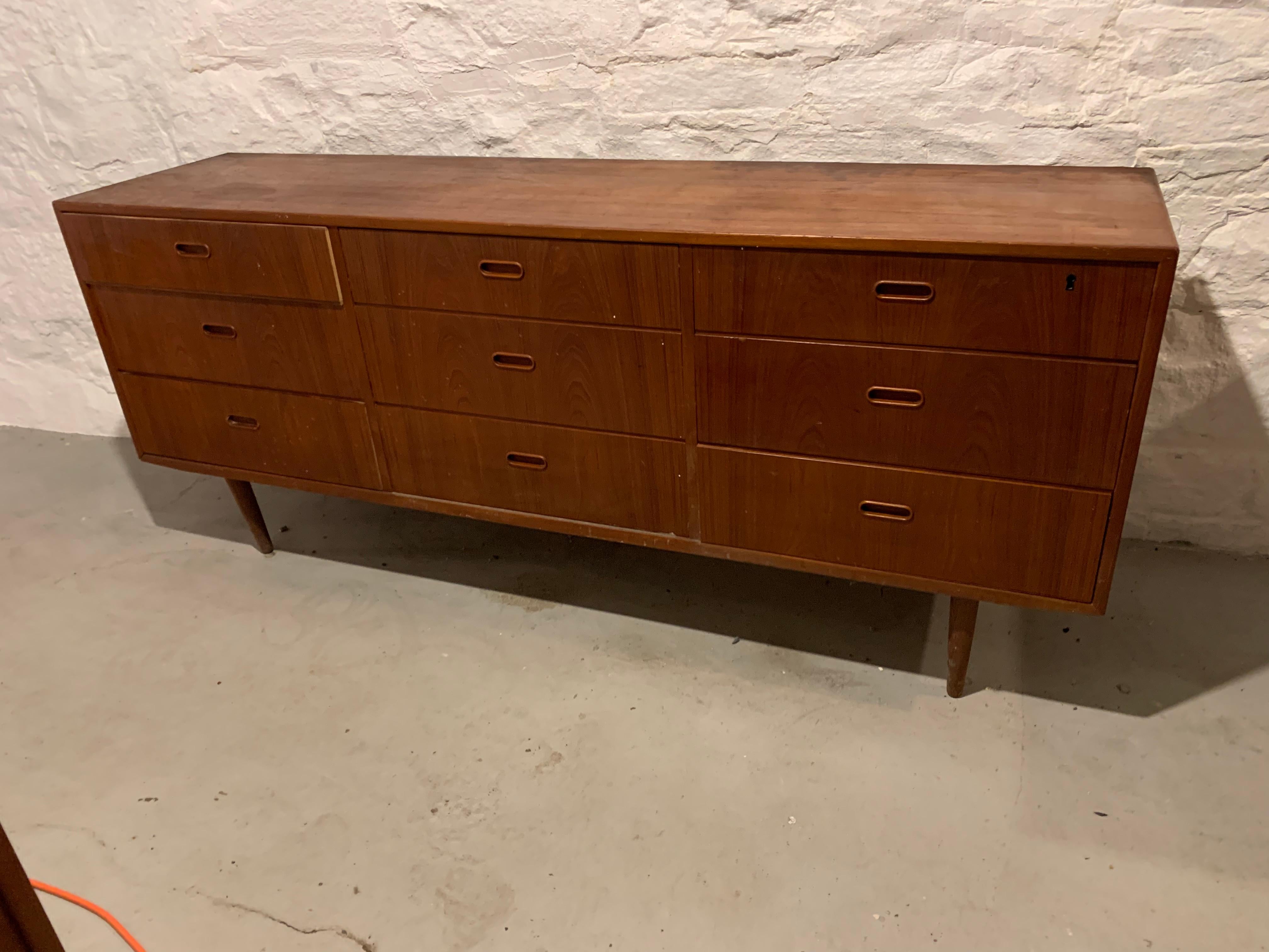 This low dresser by Falster Møbelfabrik comprises a lovely teak case - Its nine dovetailed drawers, one of which has a shallow sliding tray, feature recessed pulls in the organic style of Danish modernism.

Falster 9 drawer 72 W 18 D 31 H legs 9
