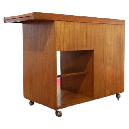 This stunning bar cart was produced in the 1960s. Produced in teak, this cart oozes mid-century charm with its elegant design and practical sliding top to hideaway bottles, making it a versatile addition to any space. At Mid Century Traders, we