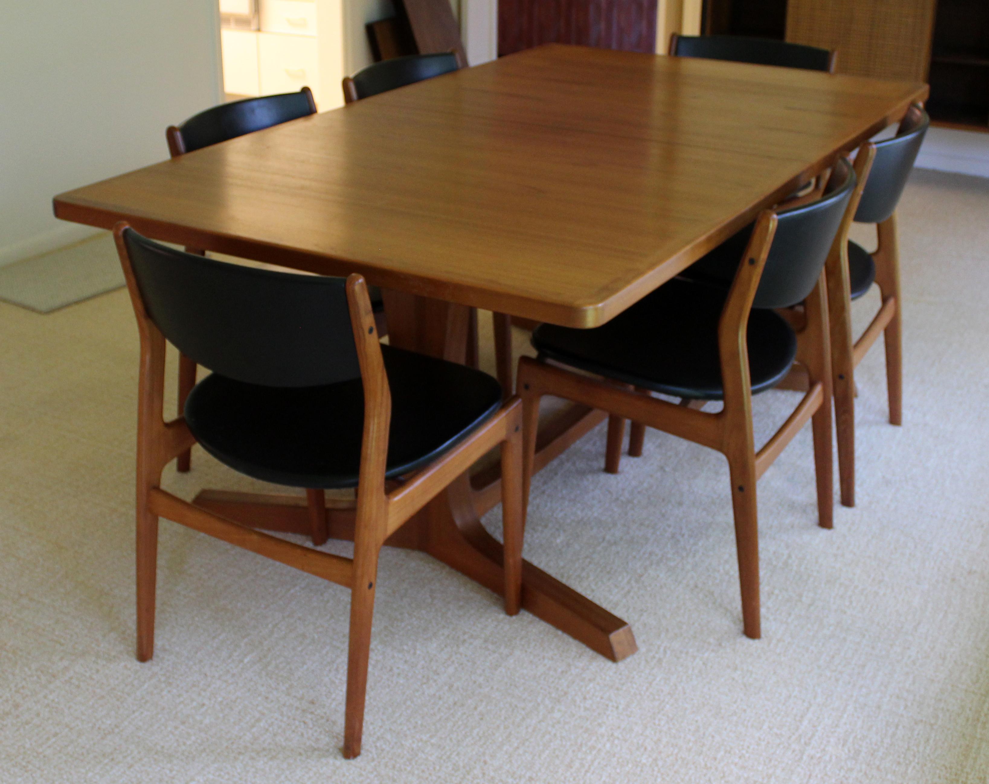 For your consideration is a gorgeous, expandable dining table, with two leaves, and six matching chairs, with black leather upholstery, circa 1960s. In excellent vintage condition. The dimensions of the table are 72.5